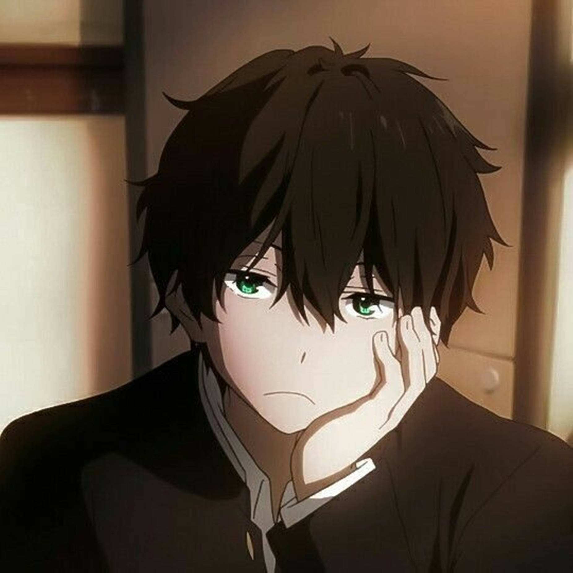 Cute Anime Boy 桌布 壁紙 — 一個年輕的動漫男孩，有著凌亂的黑髮和引人注目的綠眼睛，在光線昏暗的房間裡用手托著下巴。