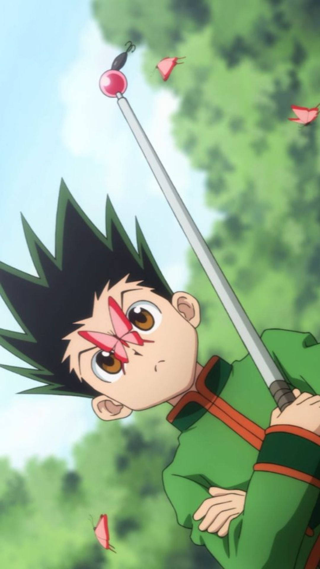 獵人 x 獵人 桌布 壁紙 — 一個年輕的動漫男孩，有著黑色刺蝟頭和臉上的粉紅色蝴蝶，手持長杖，粉紅色的蝴蝶在他周圍飛舞，背景是綠色森林。