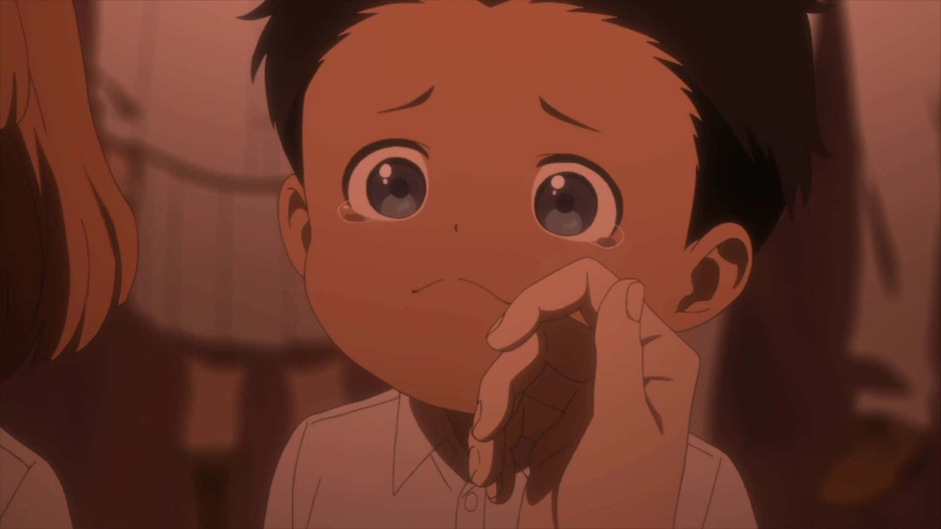 The Promised Neverland Phil 桌布 壁紙 — 一個年輕的動漫男孩，睜著充滿淚水的大眼睛，痛苦地向上看，一隻手在溫暖昏暗的場景中輕輕觸碰他的臉頰。