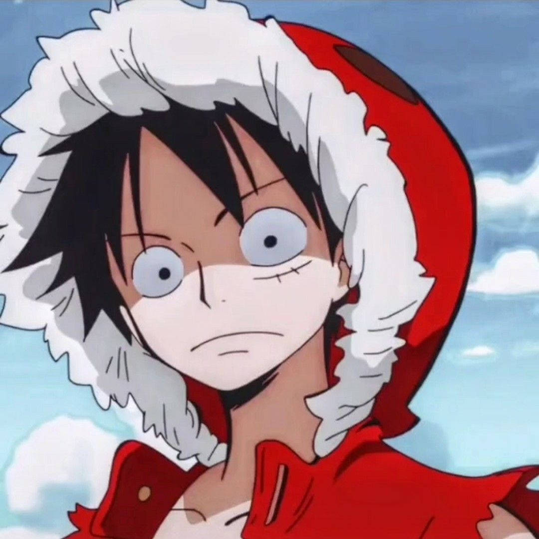 Luffy 桌布 壁紙 — 一個年輕的動漫男孩，黑髮大眼，穿著紅色連帽外套，白色毛邊，背景是多雲的天空。