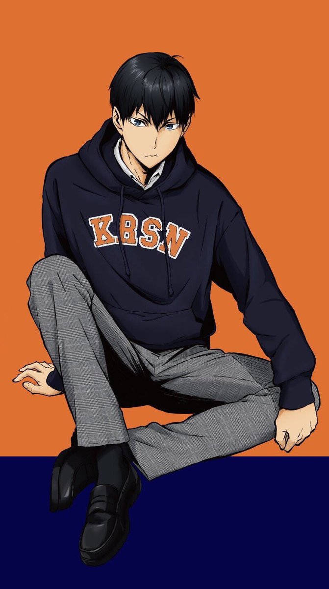 Kageyama 桌布 壁紙 — 一個年輕的動漫男孩穿著帶有橙色字母的海軍藍連帽衫，盤腿坐在大膽的橙色和海軍藍背景前。