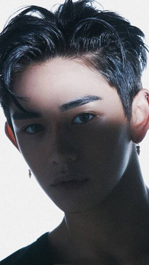 Nct 桌布 壁紙 — 一個年輕黑髮男子在戲劇性燈光下的特寫肖像，眼神銳利。