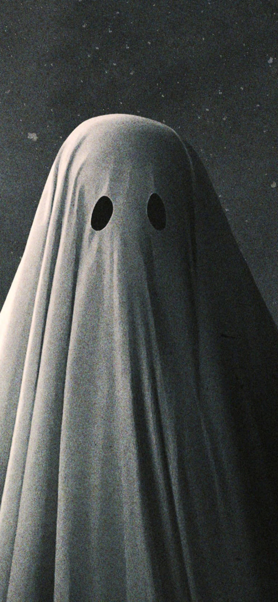 一個穿著灰色床單、有眼洞的幽靈，背景是繁星點點的夜空。 — 鬼魂 GIF 壁紙