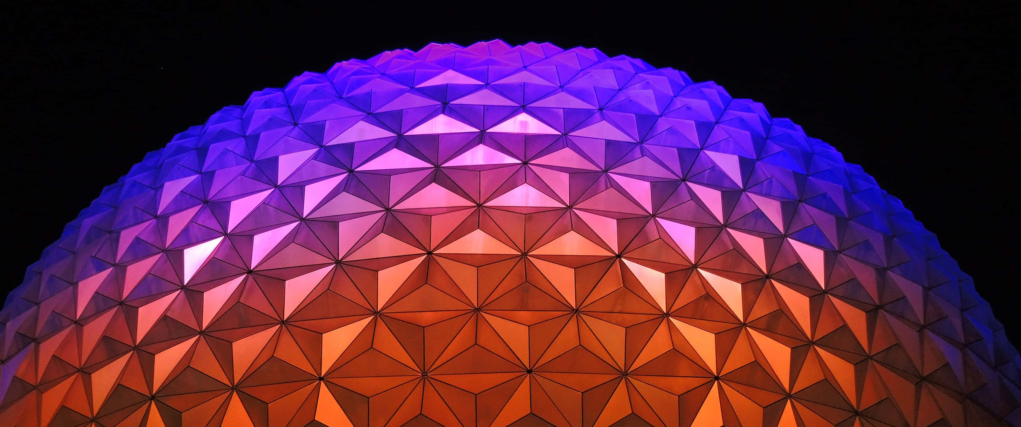 Disney World Desktop 桌布 壁紙 — 一個幾何圓頂在黑色夜空下發出由紫色到橙色的漸變光芒。
