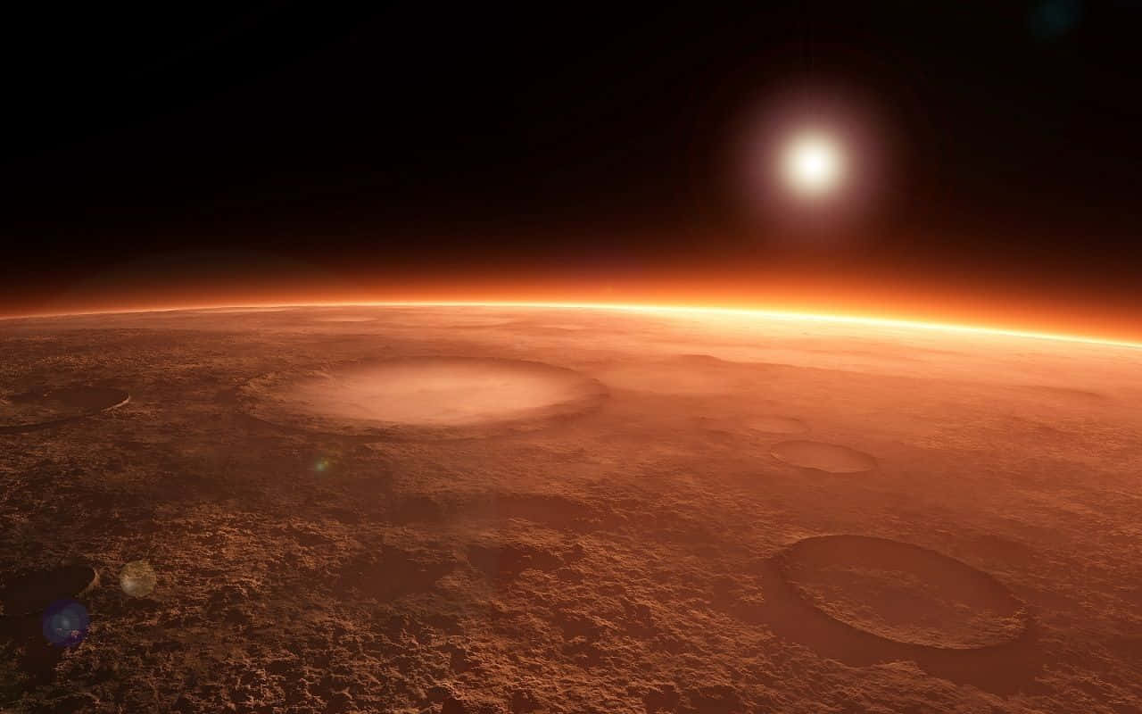 The Martian 桌布 壁紙 — 一個廣闊的外星行星，具有鏽色地形和發光的大氣薄霧，在靠近地平線的明亮太陽下。