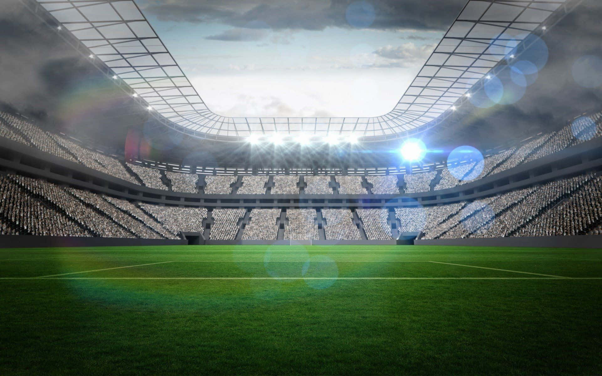 Soccer Stadium 桌布 壁紙 — 一個廣闊的空蕩蕩的體育場，明亮的泛光燈照亮了多雲天空下鬱鬱蔥蔥的綠色場地。