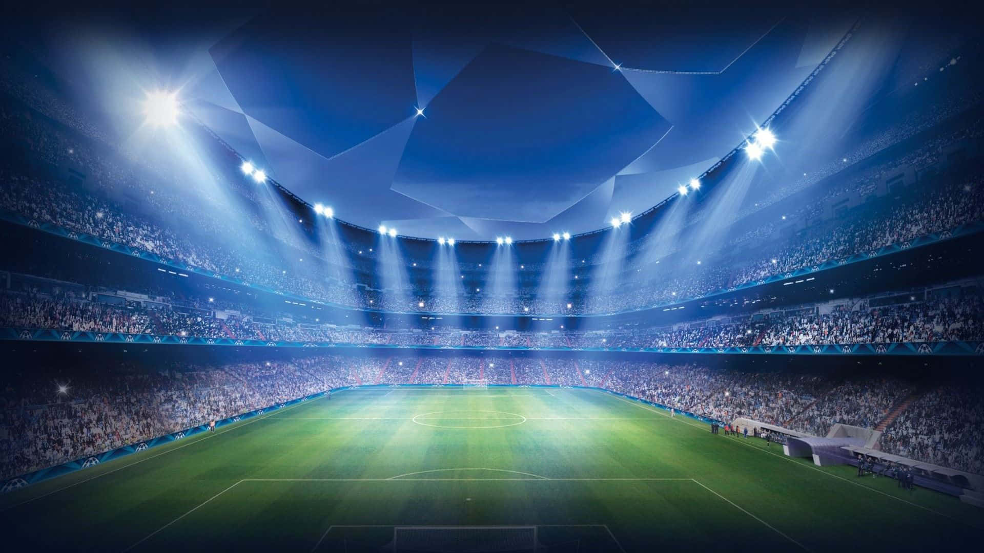 Stadium 桌布 壁紙 — 一個廣闊的足球場，沐浴在明亮的藍色聚光燈下，看台座無虛席，球場綠草如茵。