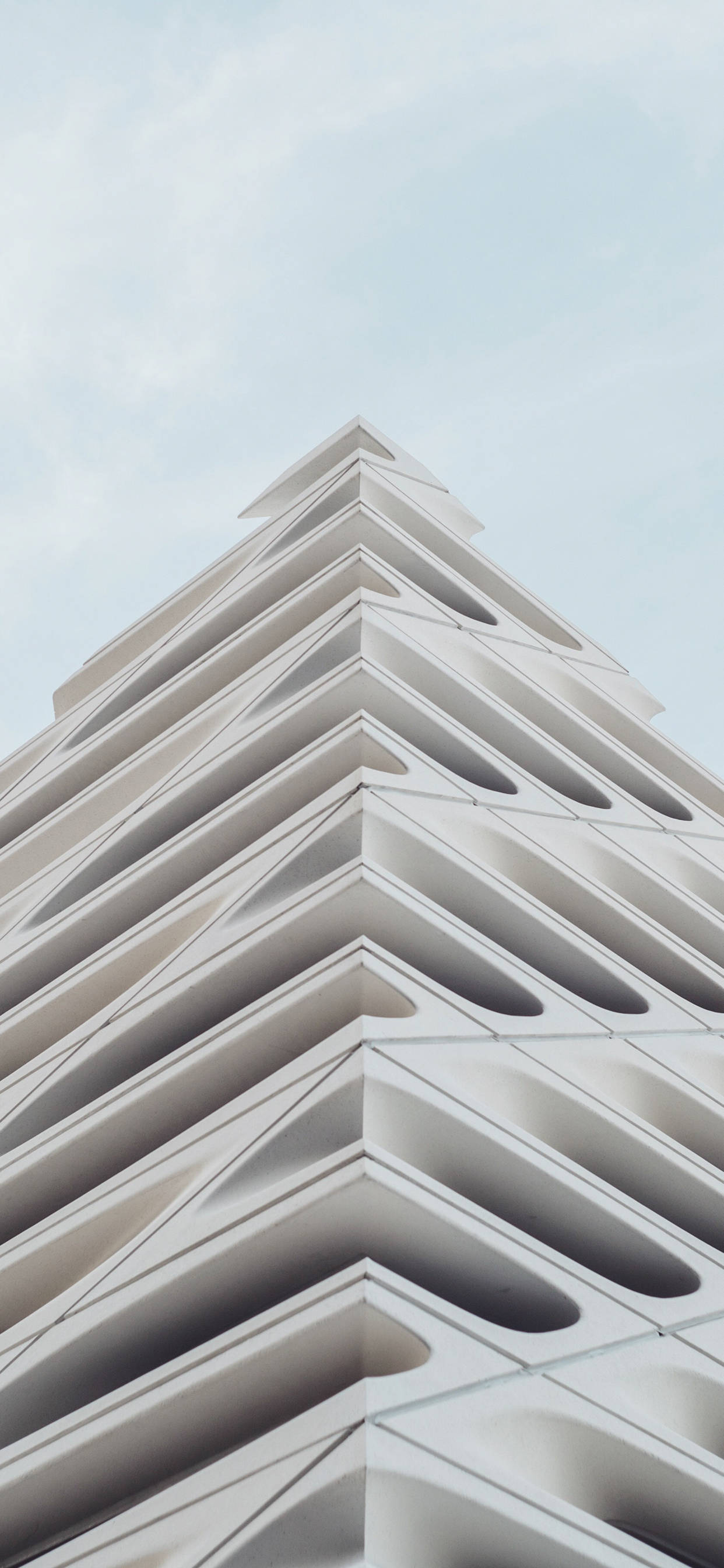 Architecture 桌布 壁紙 — 一個引人注目的低角度視角，展示現代白色建築結構，帶有重複的幾何人字形圖案，背景是淡色天空。