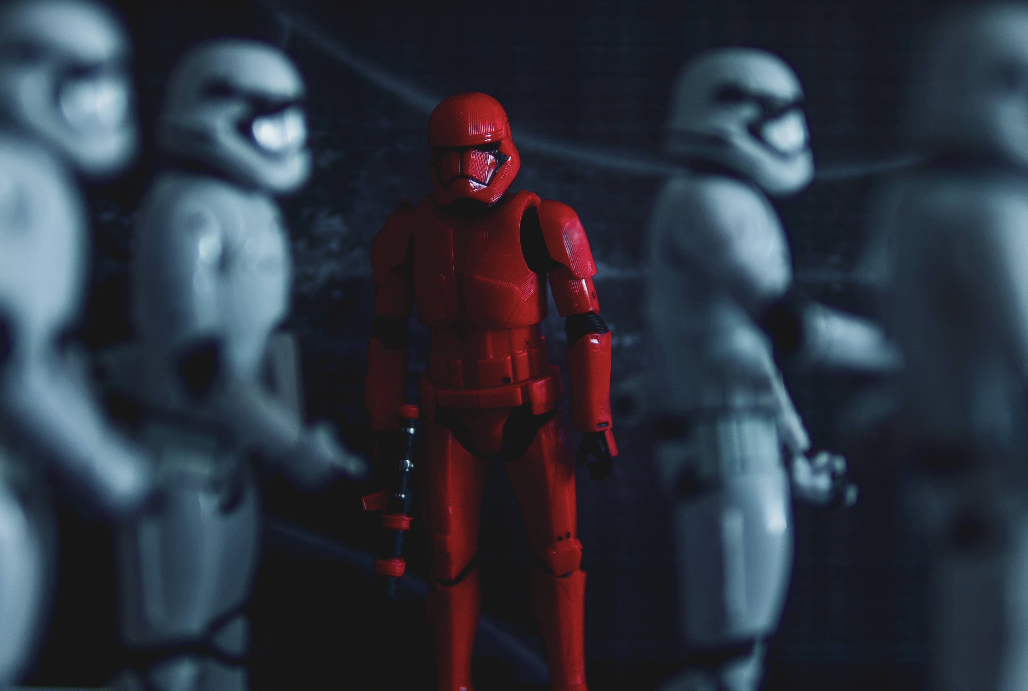 Star Wars Red 桌布 壁紙 — 一個引人注目的紅色風暴兵在昏暗的藍色燈光下，在模糊的白色風暴兵中清晰對焦。