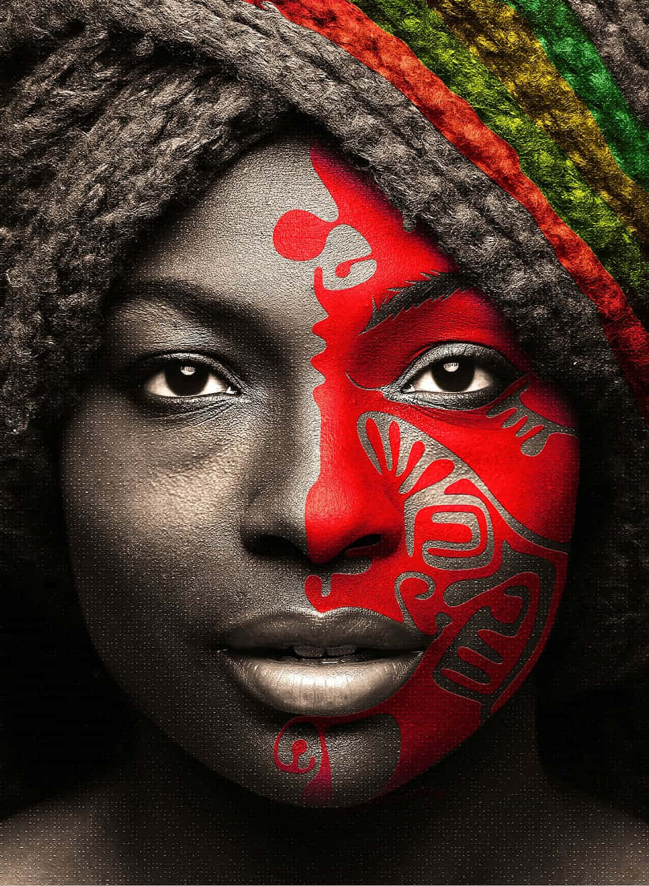 Woman 桌布 壁紙 — 一個引人注目的肖像，一位女性的半邊臉塗上大膽的紅色部落圖案，背景為單色。