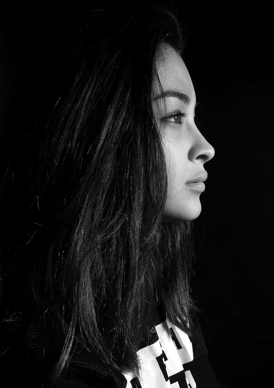 grayscale 桌布 壁紙 — 一個引人注目的黑白女性側面肖像，背景為深色，柔和光線突顯她的特徵。