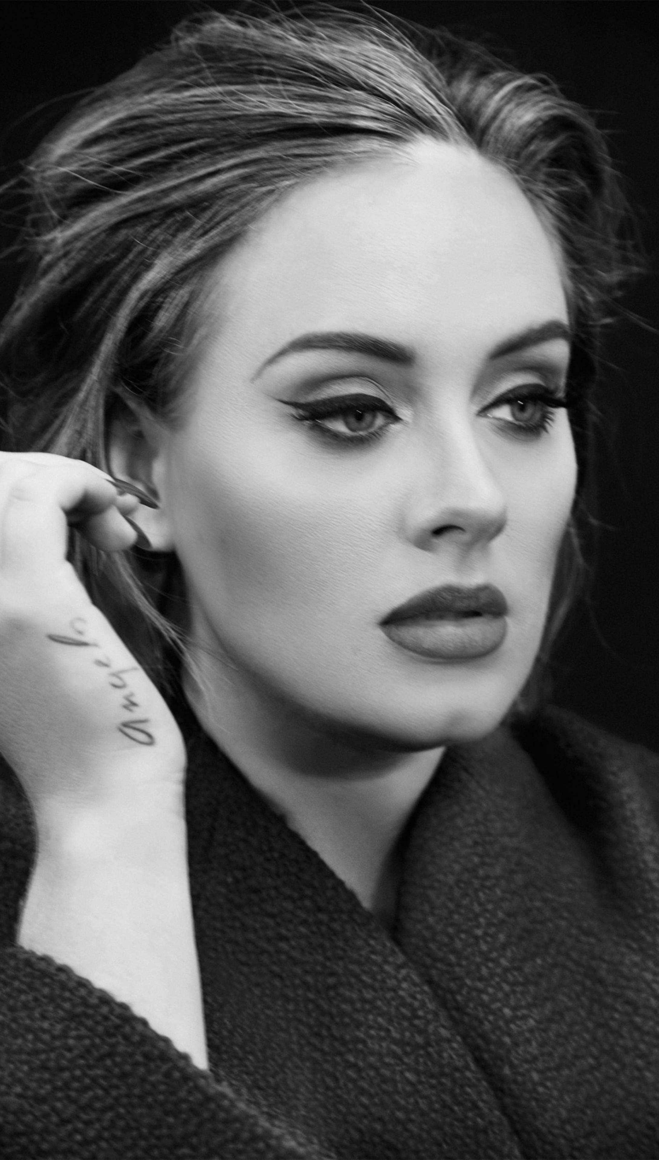 Adele 桌布 壁紙 — 一個引人注目的黑白女性肖像，帶有粗眼線和靠近耳朵的刺青手。