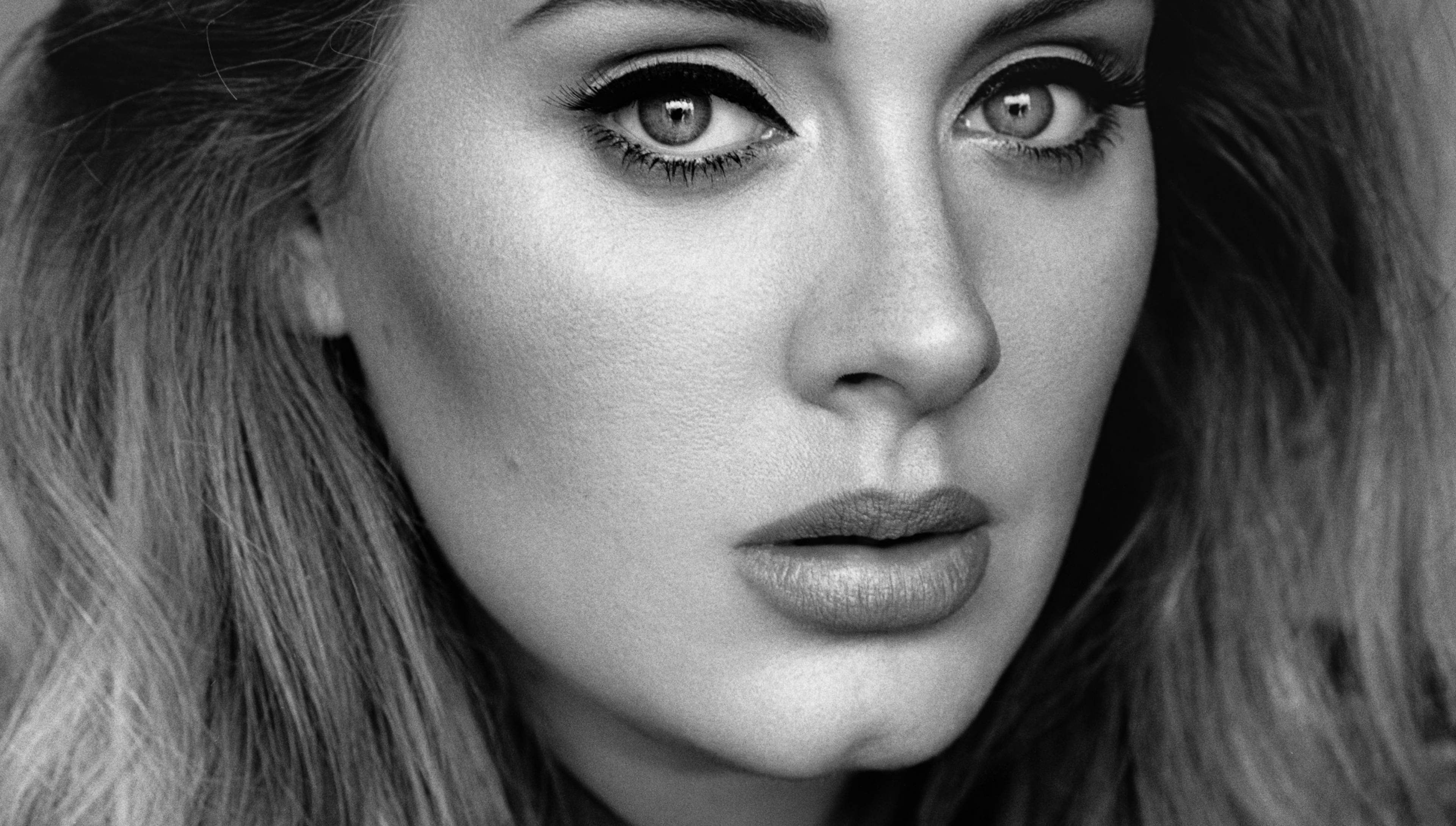 Adele 桌布 壁紙 — 一個引人注目的黑白特寫肖像，一位眼神強烈、柔軟頭髮框住臉龐的女性。