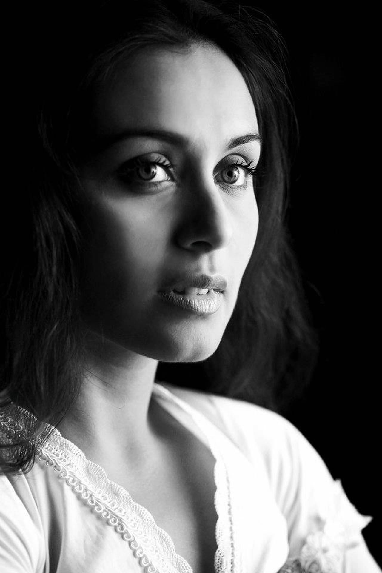 Rani Mukerji 桌布 壁紙 — 一個引人注目的黑白肖像，一位女性擁有強烈的眼神和柔軟的蕾絲領，背景為深色。