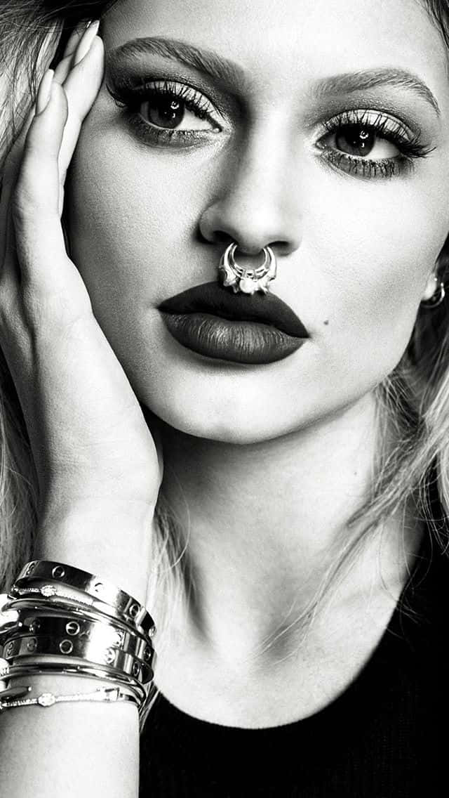 Piercing 桌布 壁紙 — 一個引人注目的黑白肖像，一位女性帶著大膽的妝容和鼻環，直視鏡頭。
