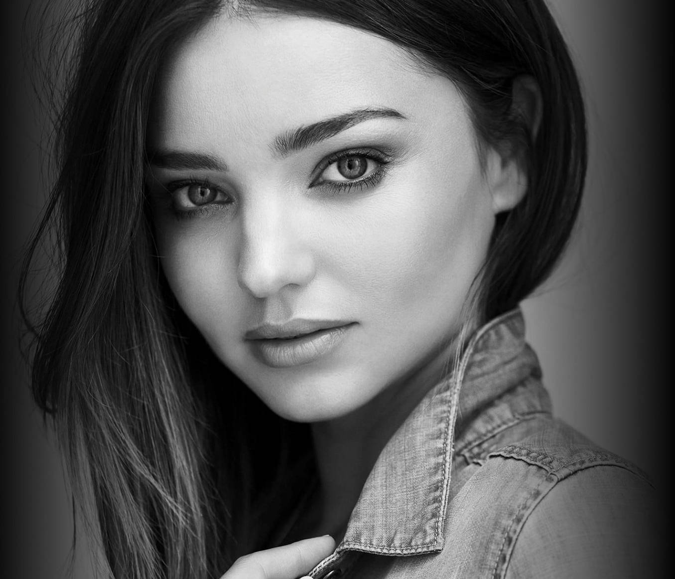 Miranda Kerr 桌布 壁紙 — 一個引人注目的黑白肖像，一位眼神銳利、頭髮柔軟的女性穿著牛仔外套。