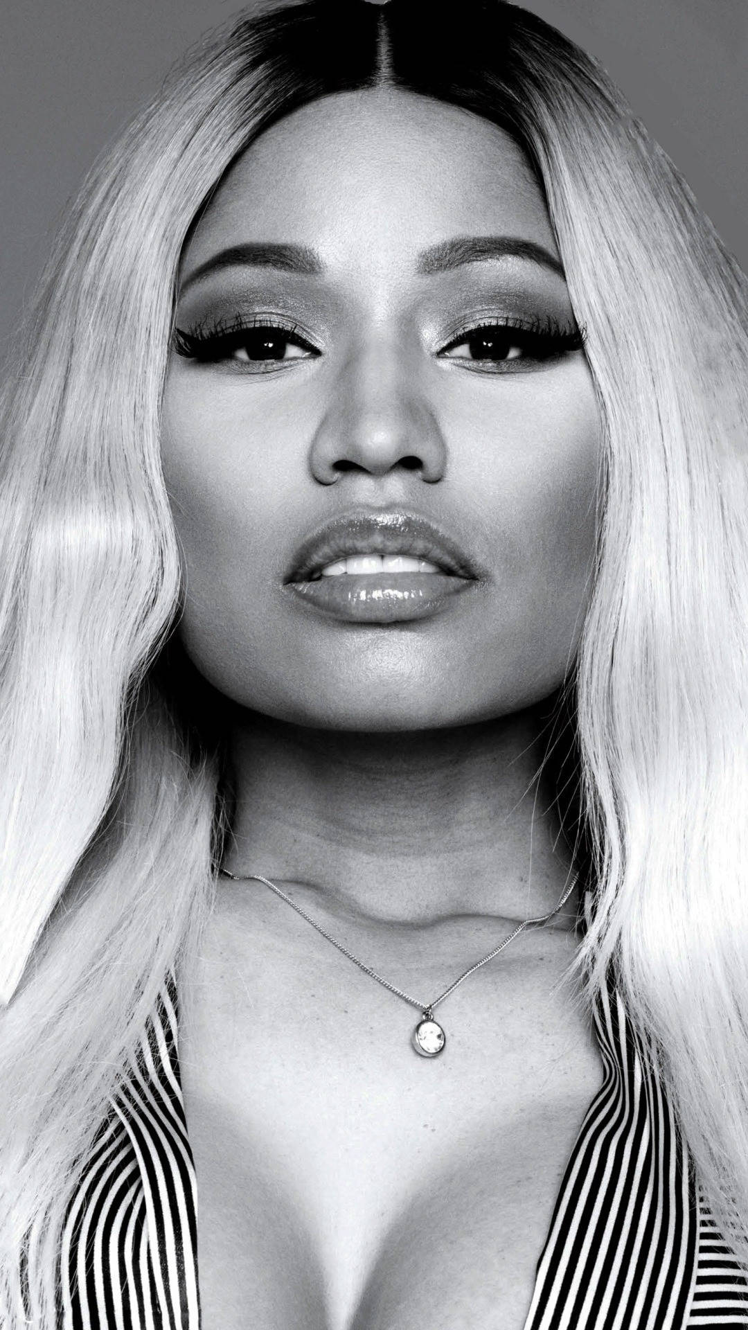 Nicki 桌布 壁紙 — 一個引人注目的黑白肖像，一位長金髮、化著大膽妝容的女性直視鏡頭。
