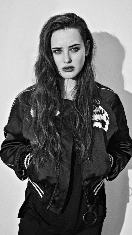 Katherine Langford 桌布 壁紙 — 一個引人注目的黑白肖像，一位長髮女性穿著帶有狼刺繡的飛行員夾克。