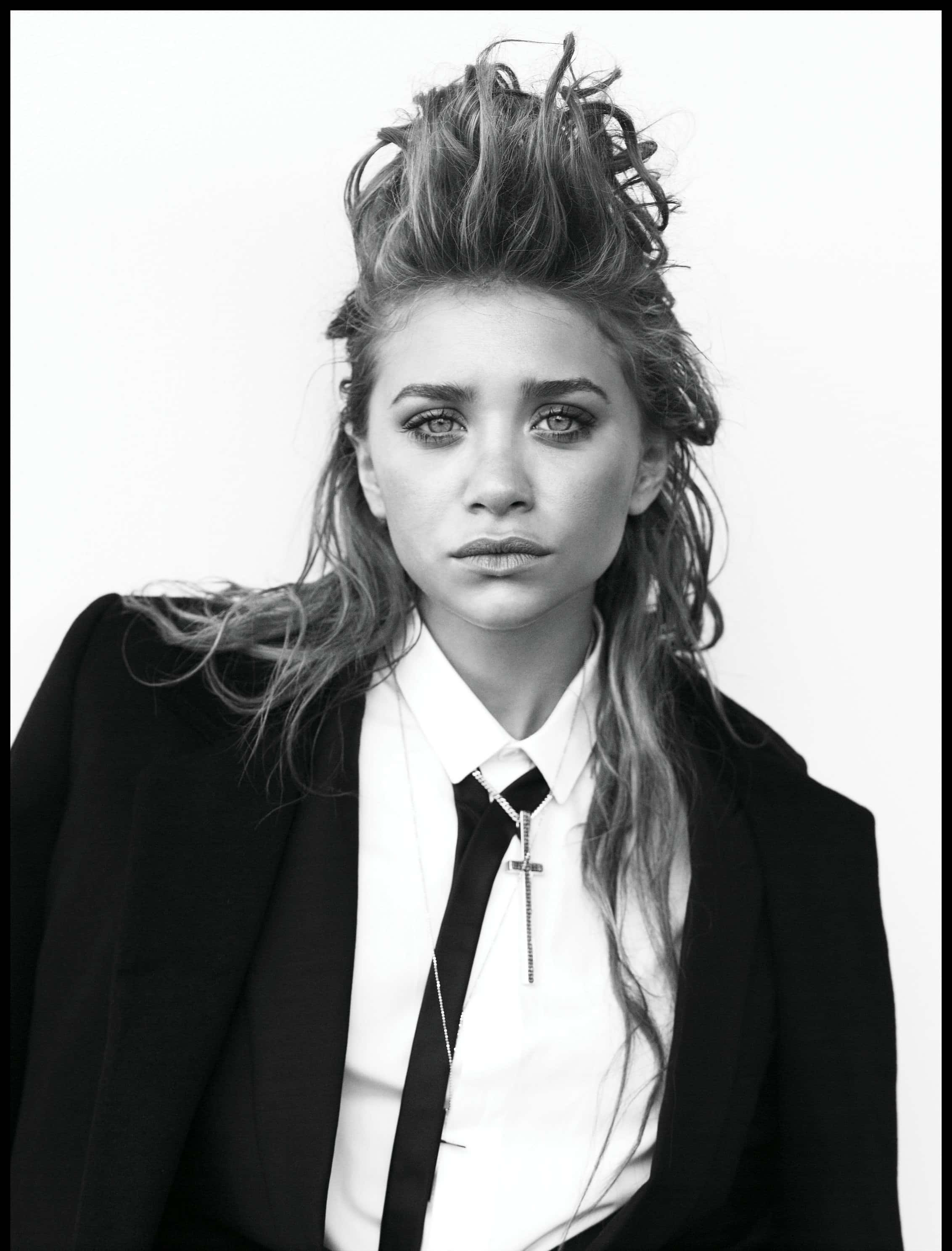 ashley olsen 桌布 壁紙 — 一個引人注目的黑白肖像，一名女子穿著西裝外套和領帶，頭髮凌亂，背景簡潔。