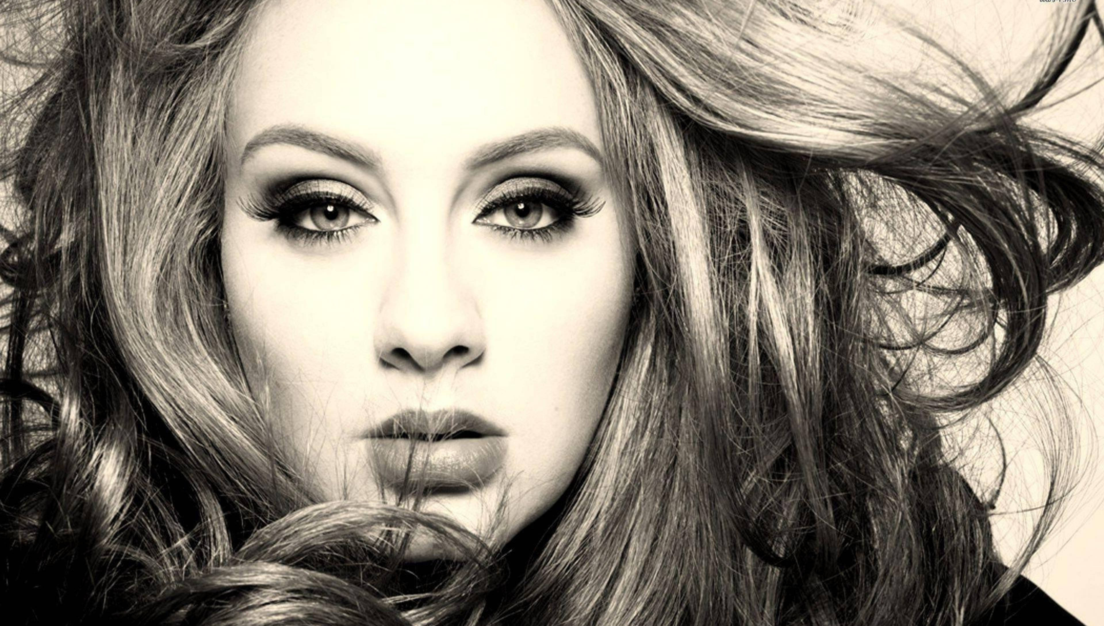 Adele 桌布 壁紙 — 一個引人注目的黑白肖像，描繪一位頭髮被風吹亂、眼神強烈的女性，直視觀眾。