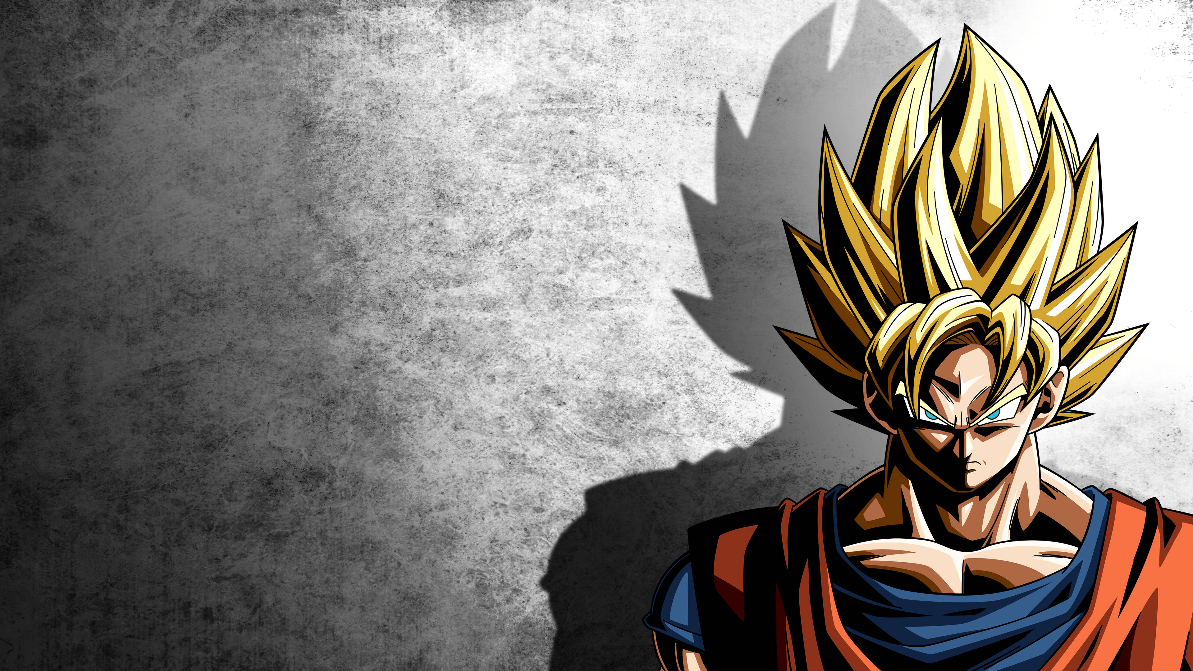 Goku Dragon Ball Super 桌布 壁紙 — 一個強大的動漫角色，擁有尖刺的金色頭髮和強烈的藍色眼睛，站在有紋理的灰色牆壁前，投射出戲劇性的陰影。