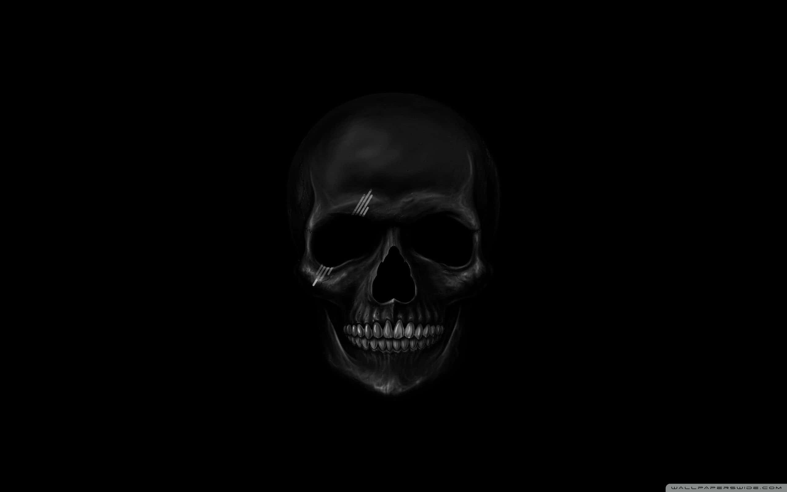 Black Skeleton 桌布 壁紙 — 一個強烈照明的人類頭骨，帶有發光的牙齒和微弱的刮痕，從絕對的黑暗中凝視出來。