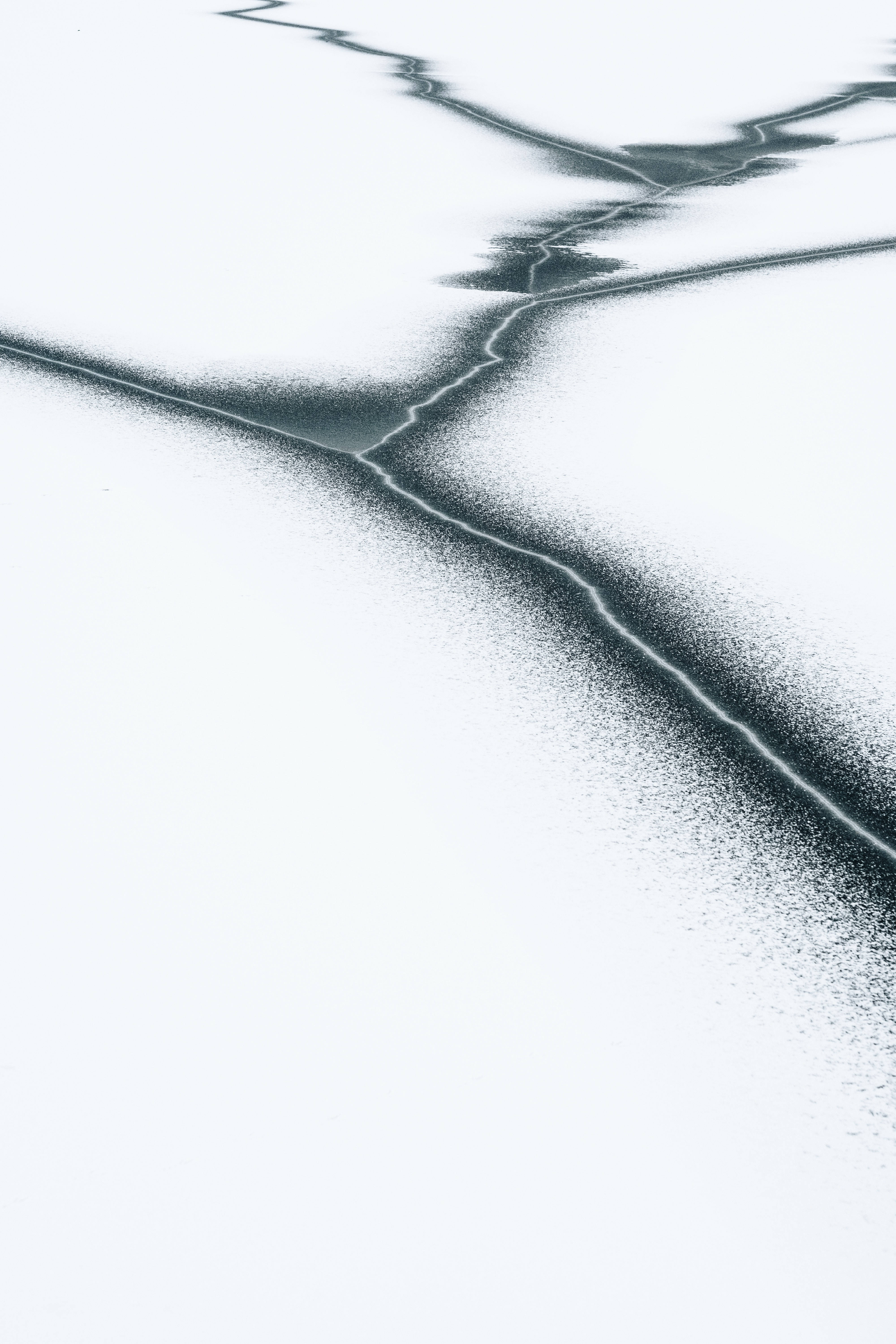 冰 桌布 壁紙 — 一個強烈的抽象圖案，黑暗裂縫穿過廣闊的白雪。