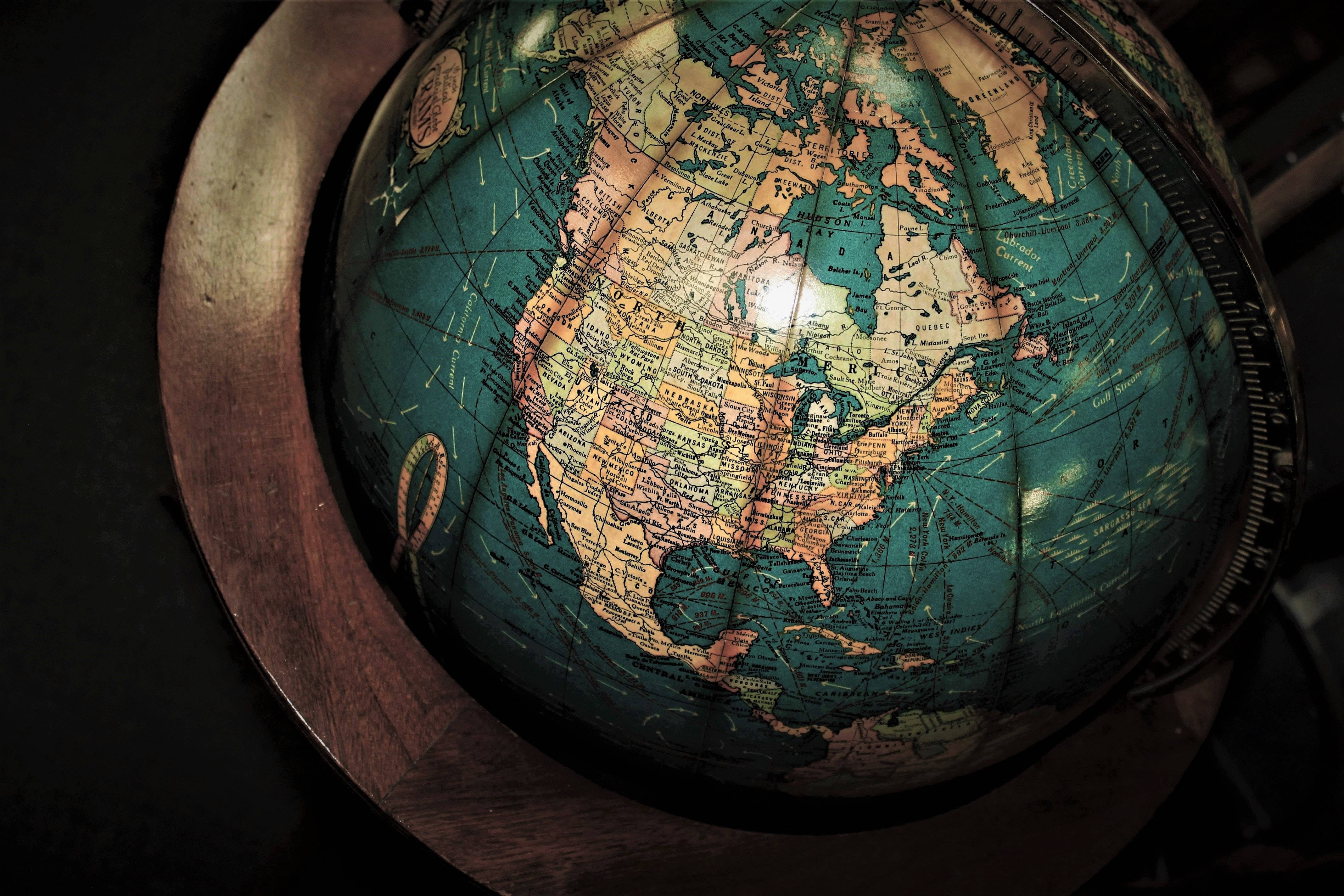 United States Map 桌布 壁紙 — 一個復古地球儀，細節豐富的大陸，在黑暗背景下表面散發溫暖的光芒。