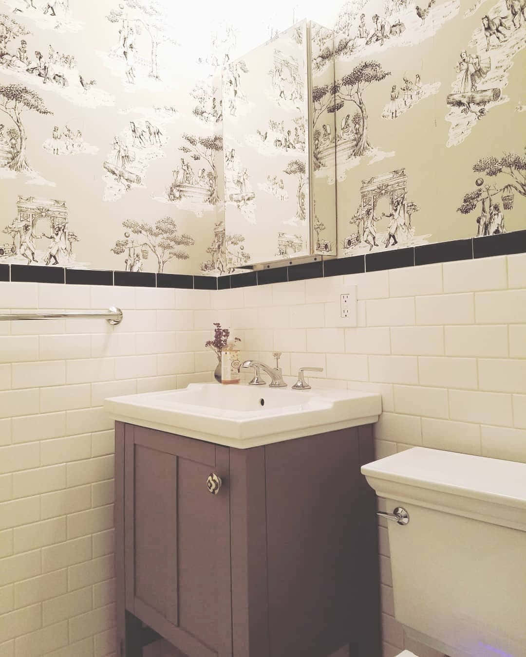 Bathroom Decor 桌布 壁紙 — 一個復古浴室，配有描繪田園場景的托伊爾壁紙，位於白色地鐵磚和深色木製梳妝台上方。