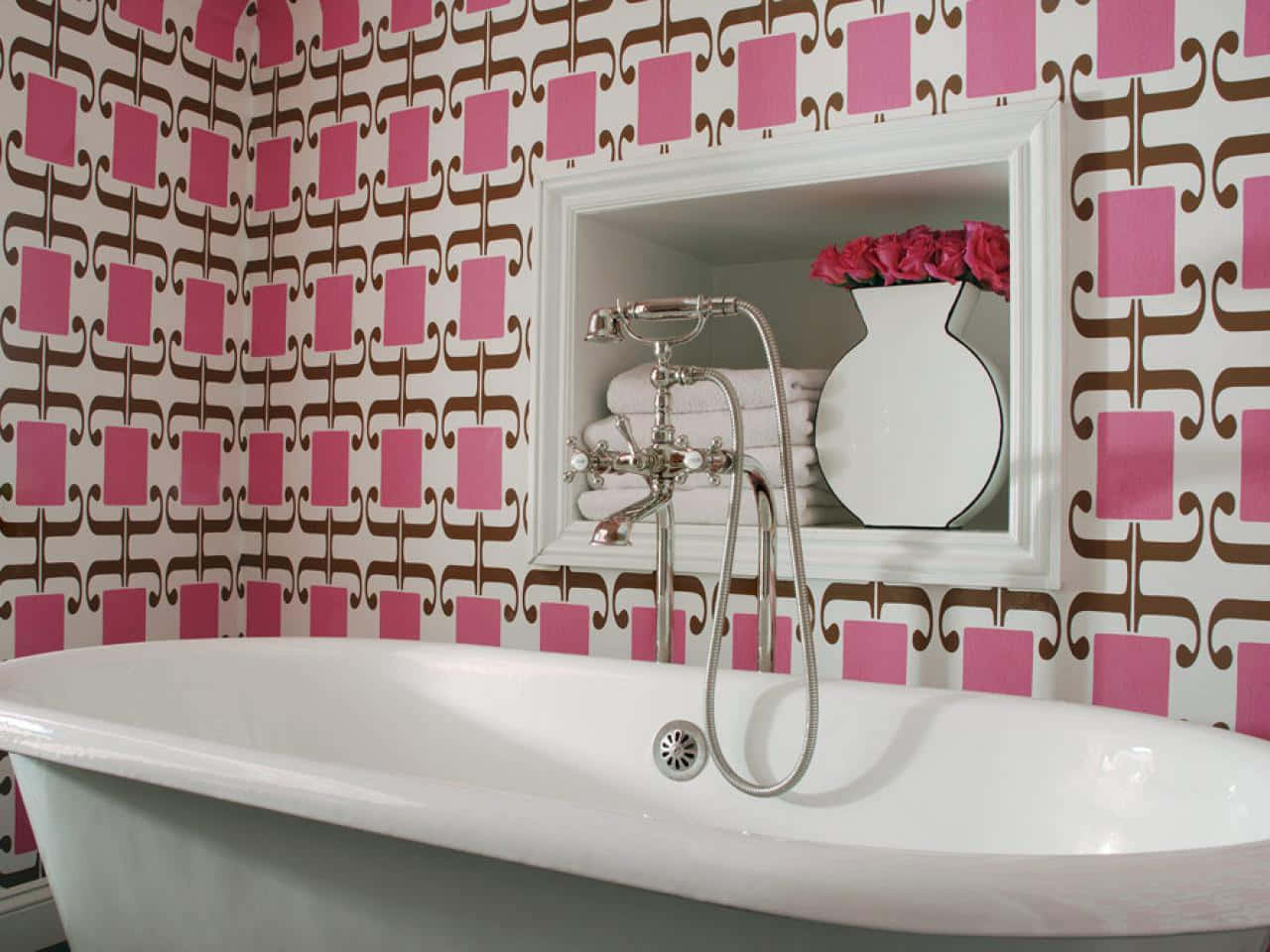 Bathroom Decor 桌布 壁紙 — 一個復古爪腳浴缸位於鏡子下方，鏡子反射出一瓶粉紅玫瑰，背景是鮮明的粉紅和棕色幾何圖案壁紙。