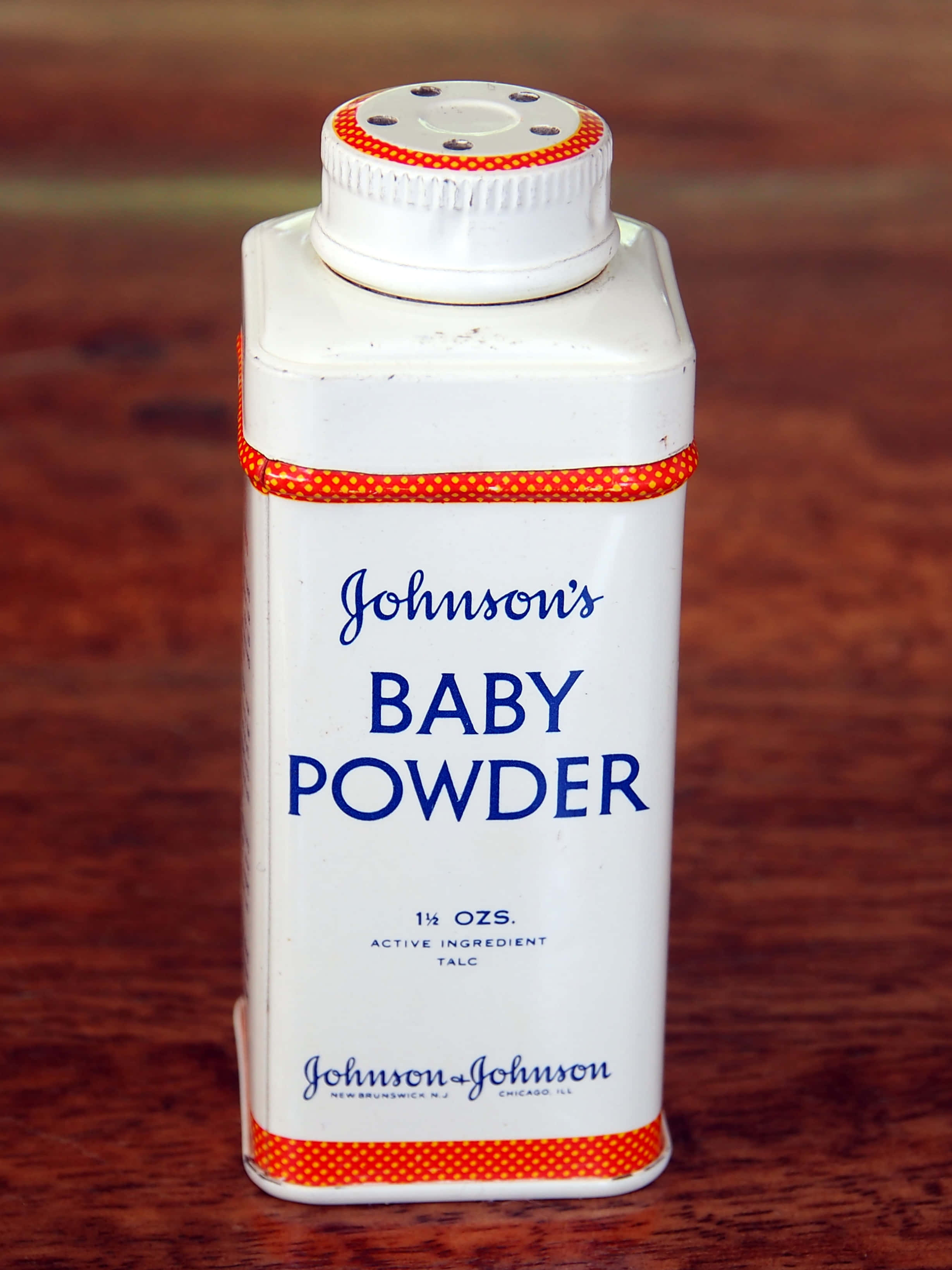 Baby Powder 桌布 壁紙 — 一個復古白色Johnson's嬰兒爽身粉罐（紅色邊框）放在溫暖的木質表面中央。