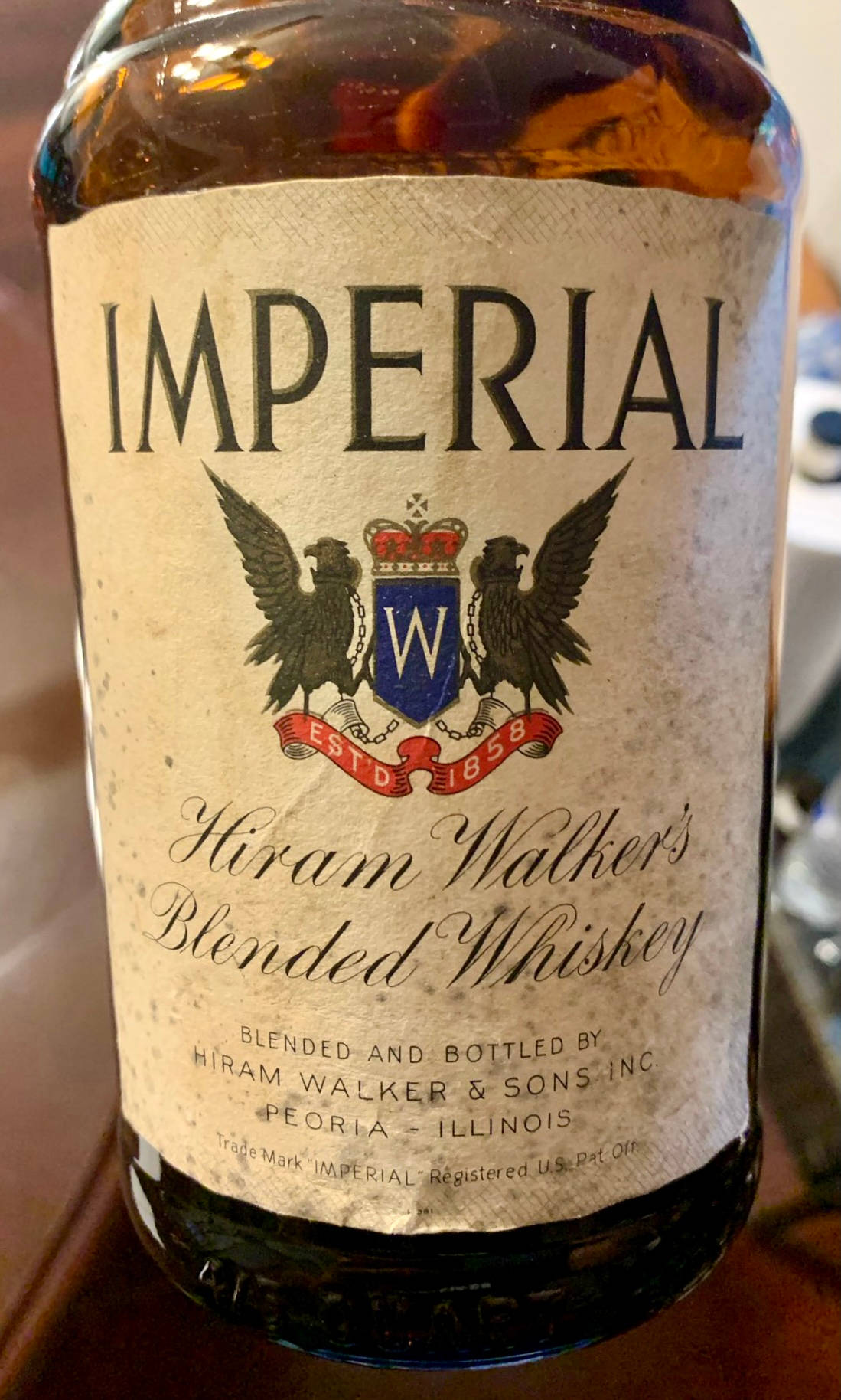 alcohol 桌布 壁紙 — 一個復古的Imperial Hiram Walker's Blended Whiskey酒瓶，帶有華麗標籤和鷹徽，放置在木質表面上。