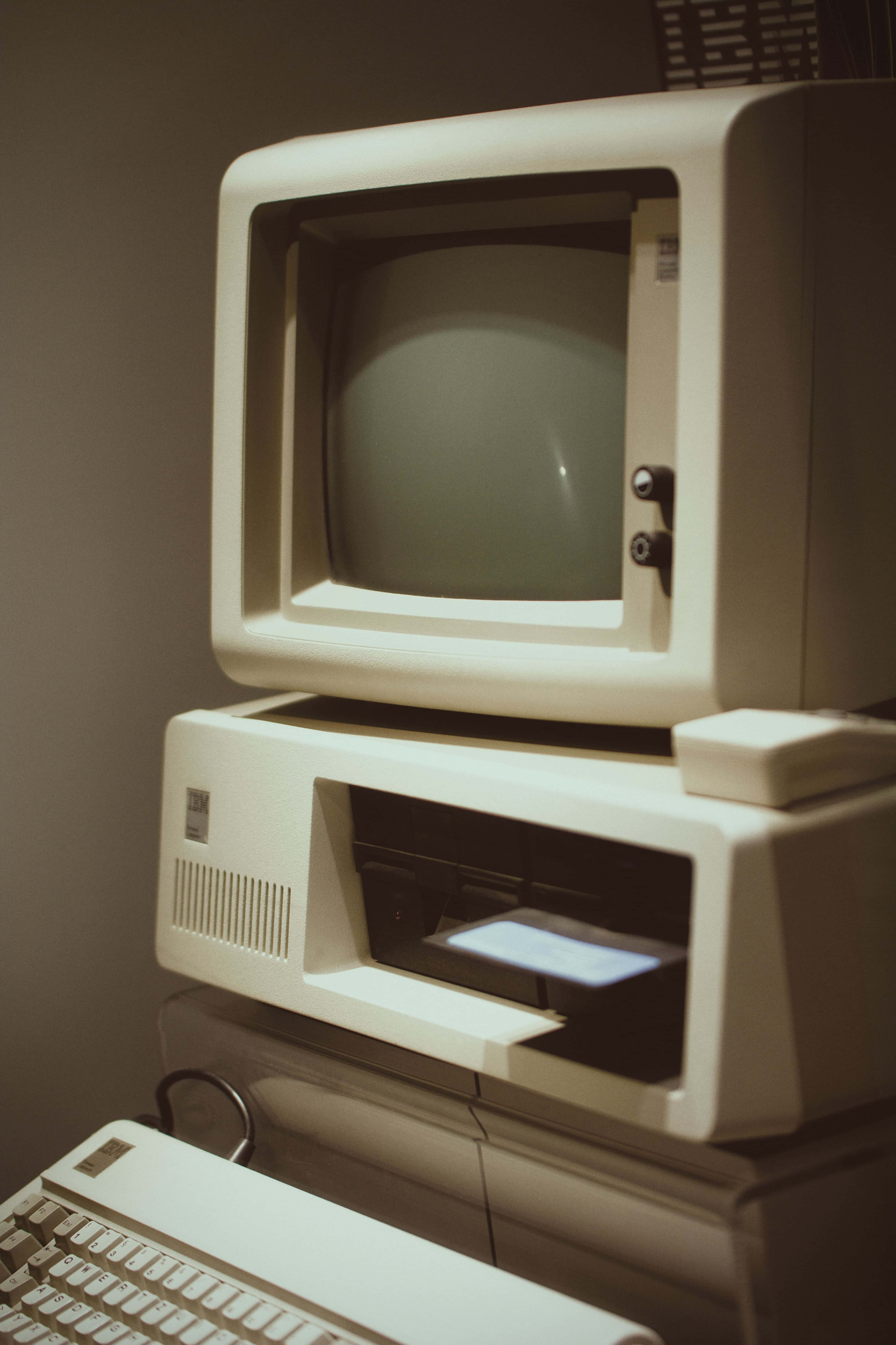 Old Pc 桌布 壁紙 — 一個復古米色電腦組合，配備CRT顯示器、印表機和鍵盤，沐浴在溫暖懷舊的光線中。