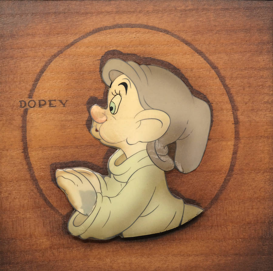 Dopey 桌布 壁紙 — 一個復古迪士尼Dopey別針，柔和粉彩顏色，放在溫暖的木質表面上，附近刻有他的名字。