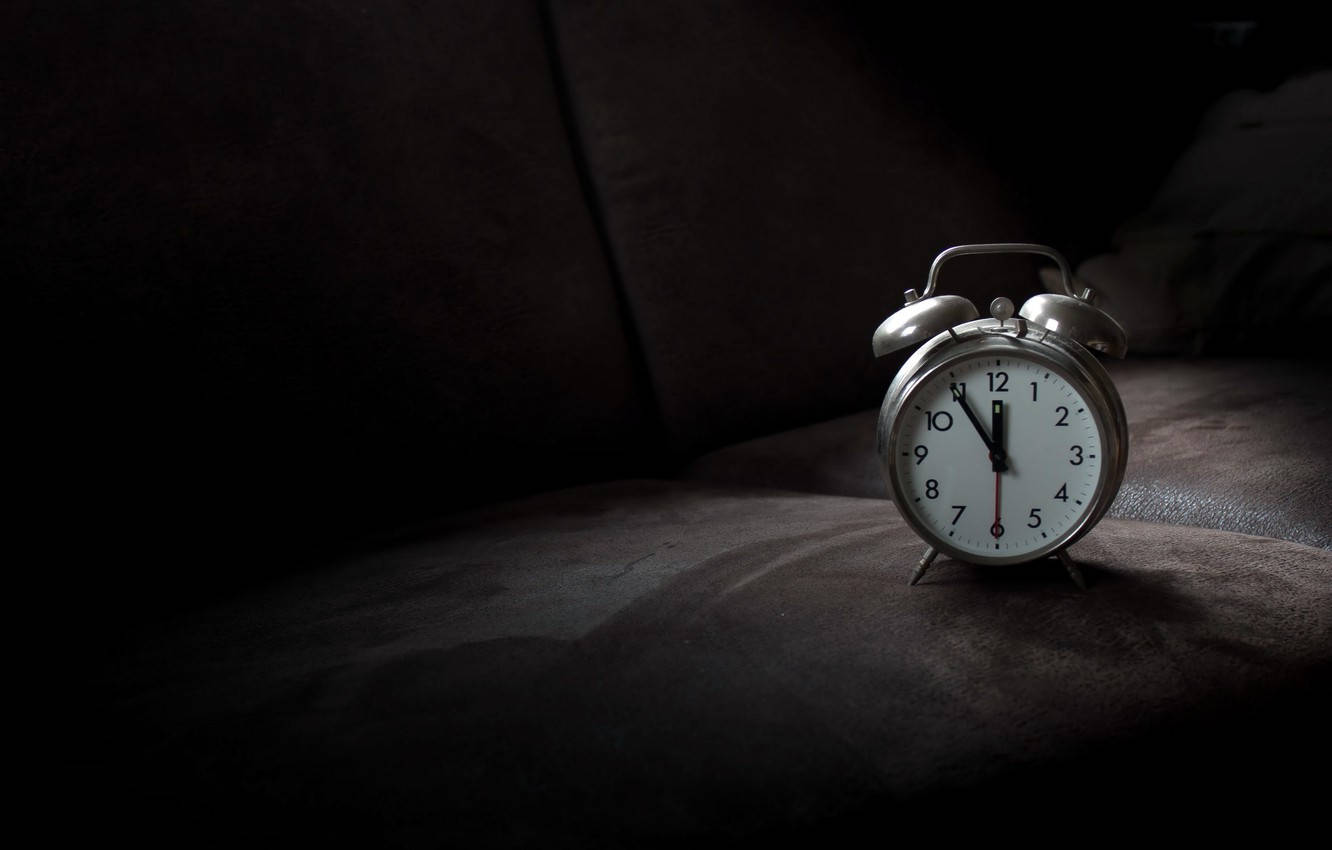 Clock 桌布 壁紙 — 一個復古銀色鬧鐘，白色錶盤，放置在深色紋理表面上，在戲劇性的聚光燈下。