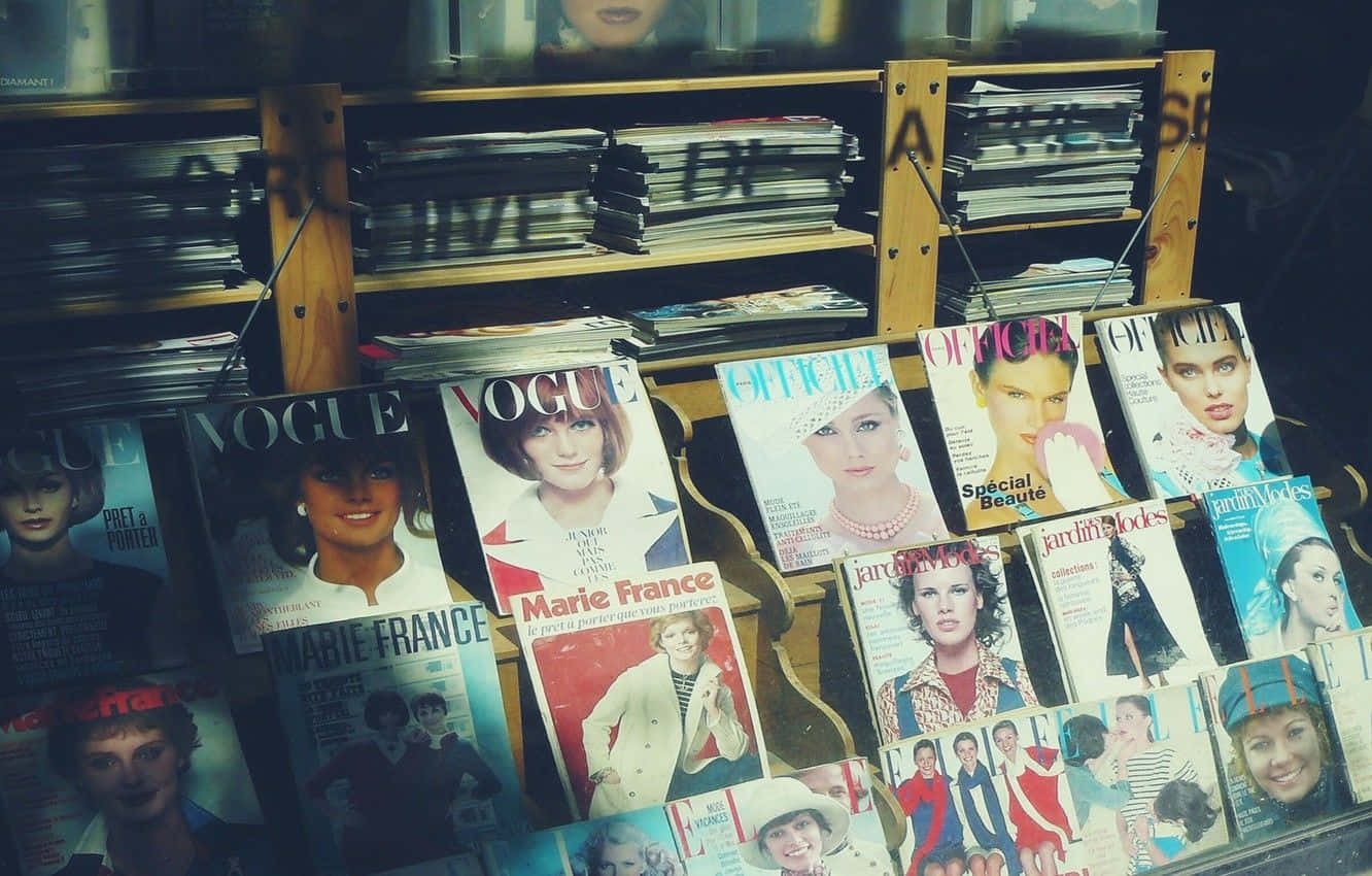 雜誌 桌布 壁紙 — 一個復古雜誌架展示經典Vogue和Marie France封面， featuring 1960年代和70年代的迷人時尚模特兒。
