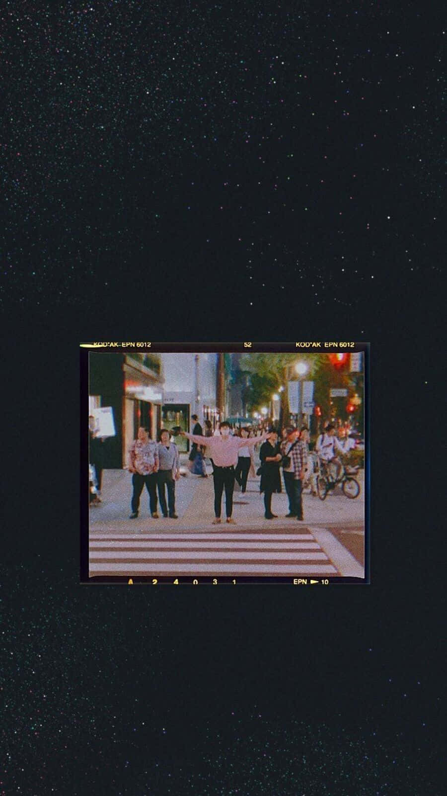 90's Vintage Retro Aesthetic 桌布 壁紙 — 一個復古電影畫面顯示一群人在星空下夜晚過馬路。