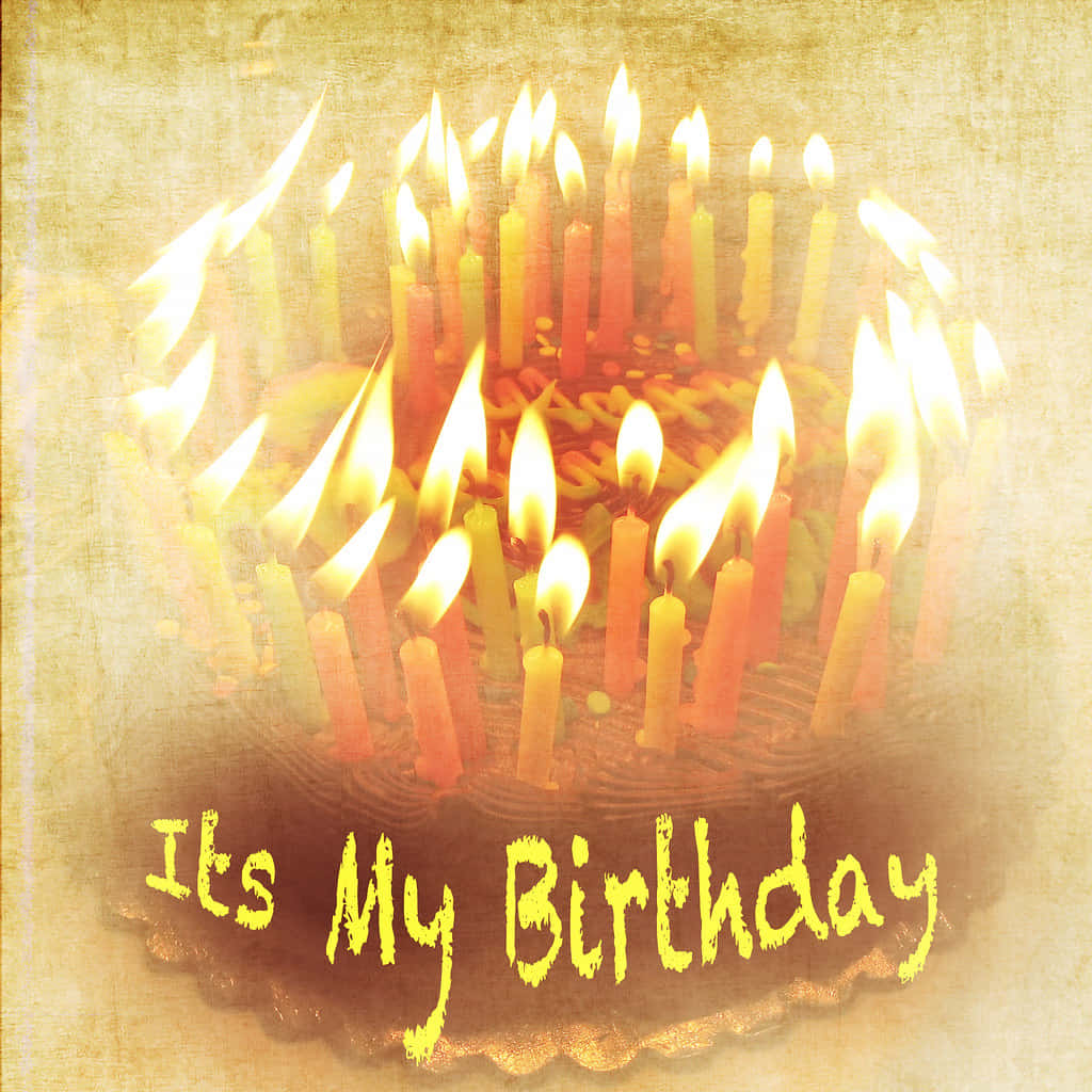 Birthday 桌布 壁紙 — 一個復古風格的生日蛋糕，上面有色彩繽紛的點燃蠟燭，以及「It's My Birthday」文字在紋理背景上溫暖地發光。