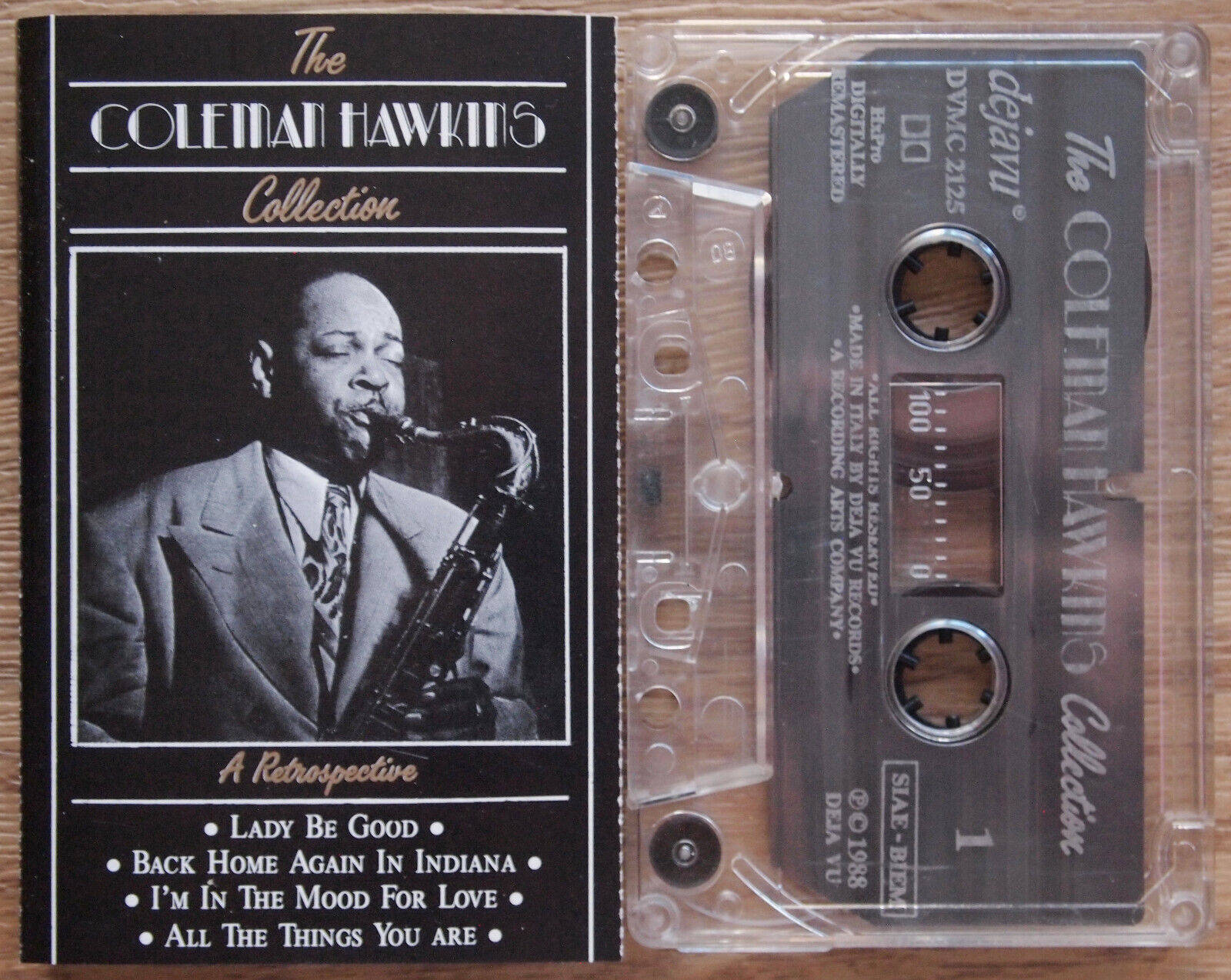 band 桌布 壁紙 — 一個復古黑白卡式錄音帶和The Coleman Hawkins Collection的專輯封面，放在木質表面上。