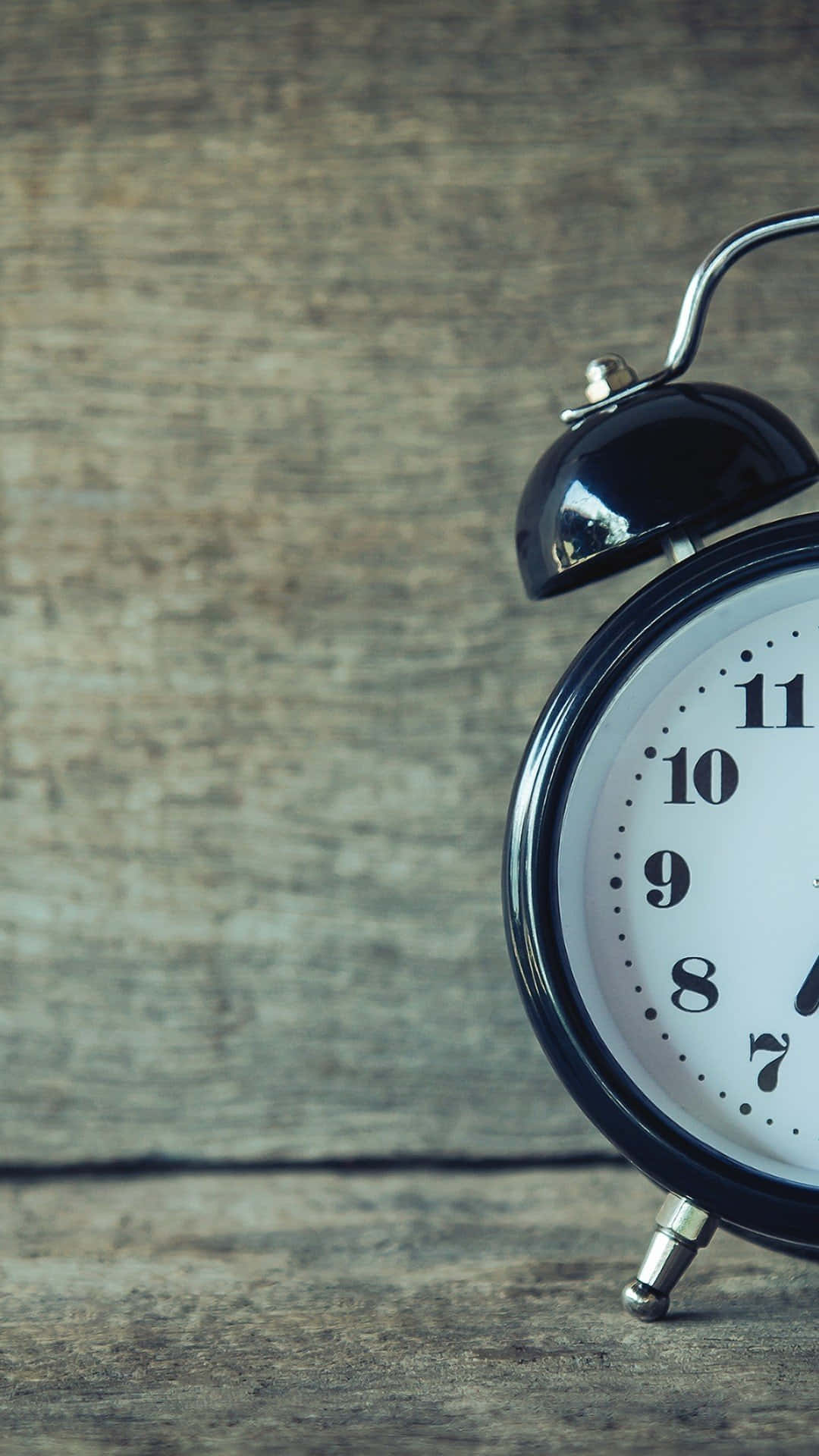 Time 桌布 壁紙 — 一個復古黑色鬧鐘，白色錶盤，放在經風化的木質表面上，鈴鐺翹起，彷彿剛剛響過。