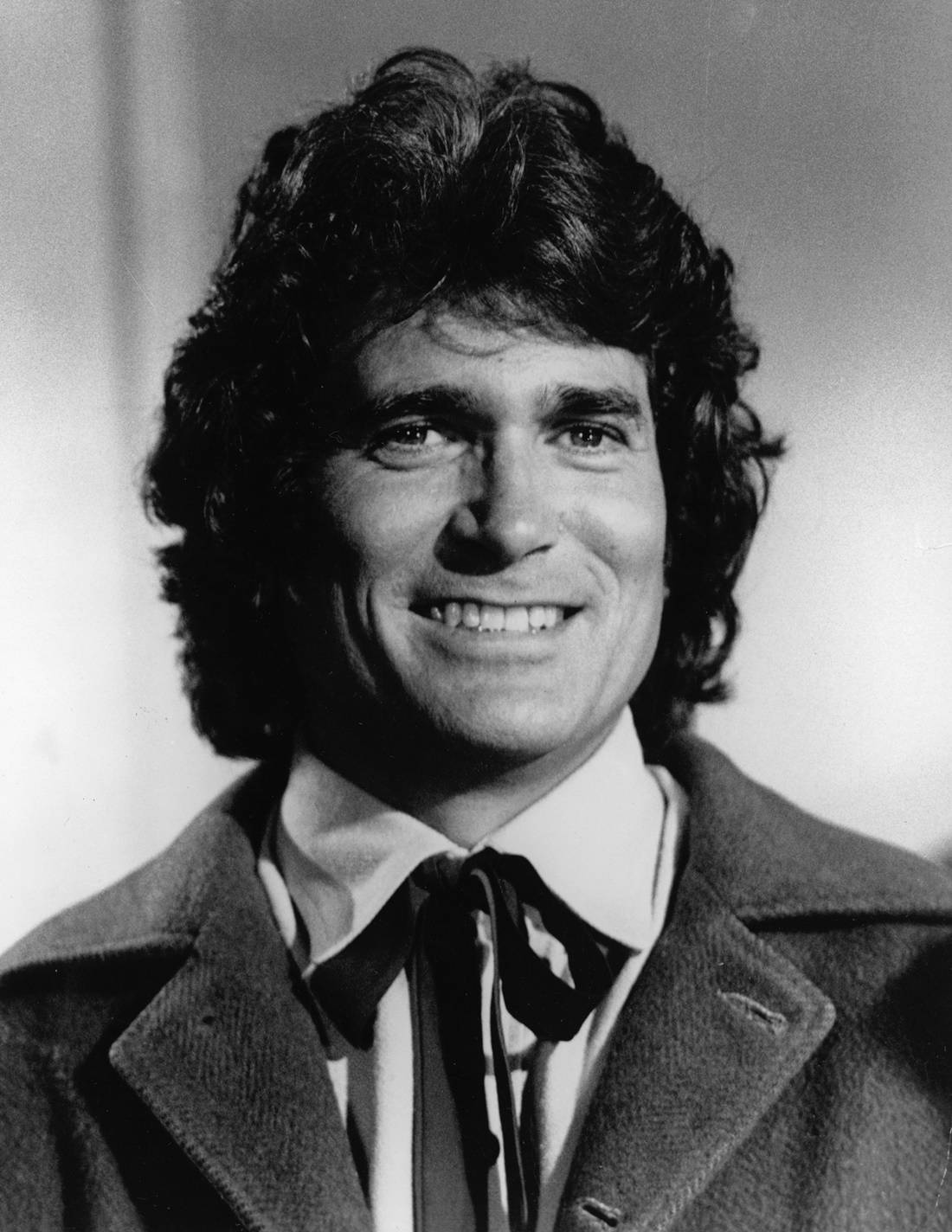 Michael Landon 桌布 壁紙 — 一個微笑、捲髮、穿著外套和領結的男士的黑白肖像。