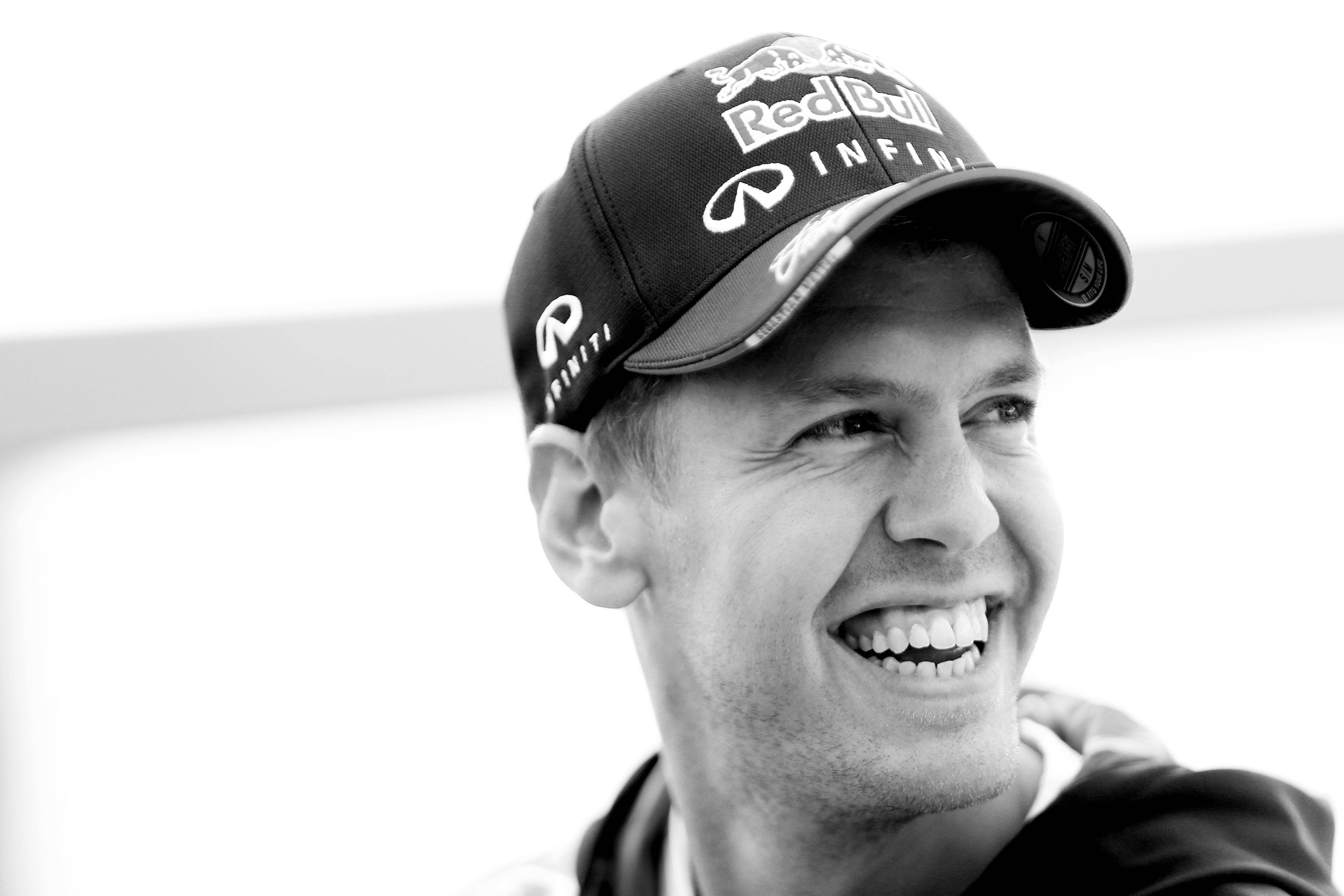 sebastian vettel 桌布 壁紙 — 一個微笑男士的黑白特寫，他戴著有 Infiniti 標誌的 Red Bull 帽。