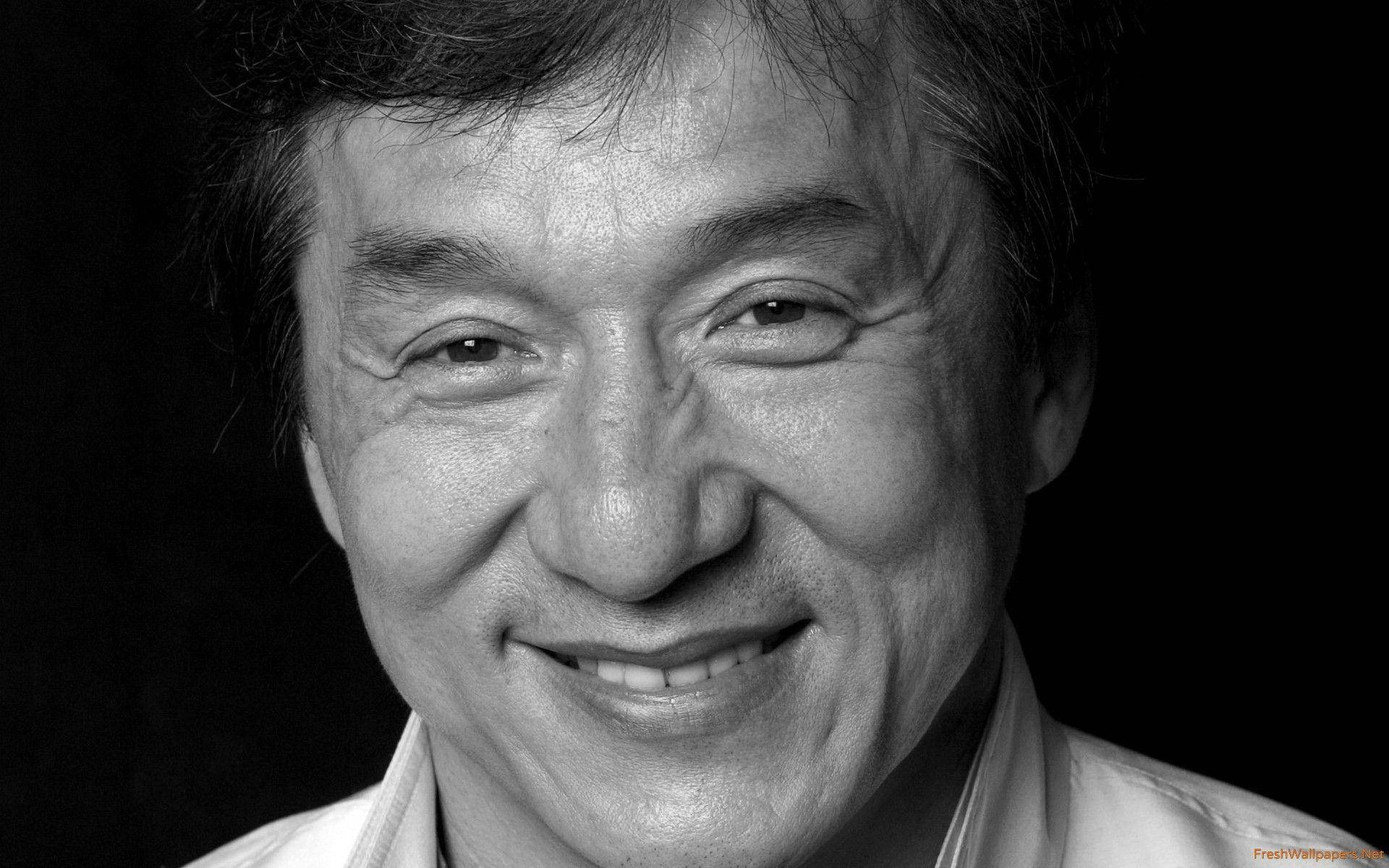  壁紙 — 一個微笑男士的黑白特寫肖像，眼神富有表現力，帶有溫暖的皺紋，背景為深色。