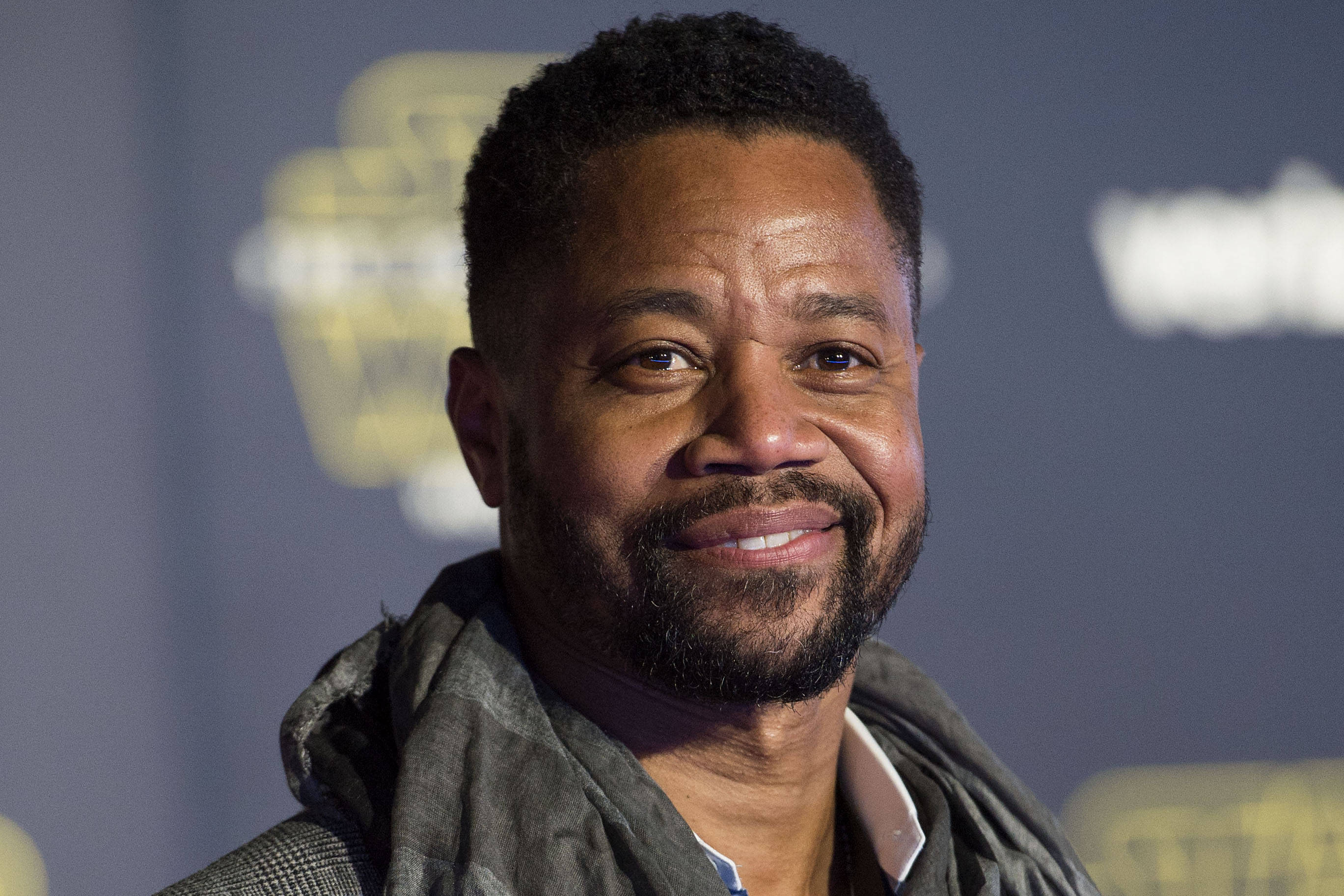 actor 桌布 壁紙 — 一個微笑留鬍鬚的男人戴著圍巾的特寫肖像，背景是模糊的活動場景。
