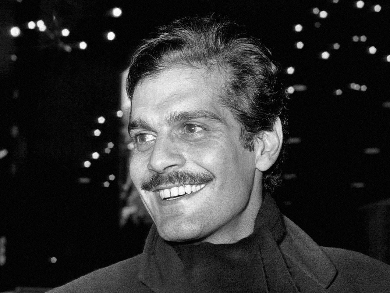 actor 桌布 壁紙 — 一個微笑留鬍鬚的男人黑白肖像，背景是夜晚模糊的城市燈光。