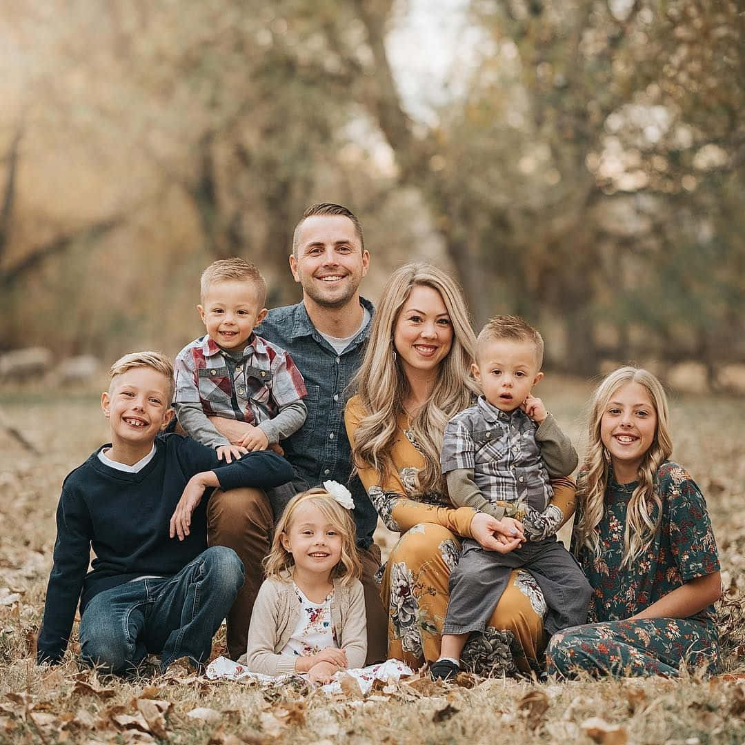 Family 桌布 壁紙 — 一個微笑的六口之家在陽光明媚的秋日森林中，一起在落葉上擺姿勢。