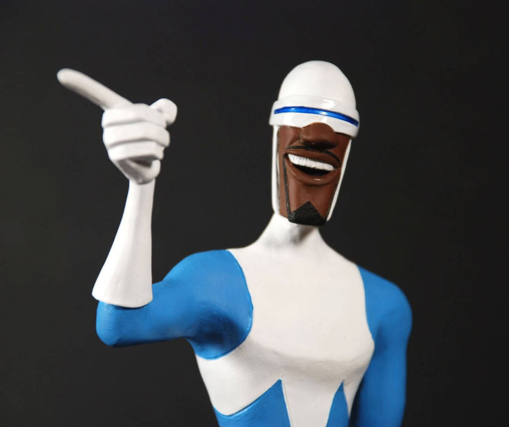 Frozone 桌布 壁紙 — 一個微笑的動畫超級英雄人物，身穿白色和藍色套裝，在深色背景下向上指。