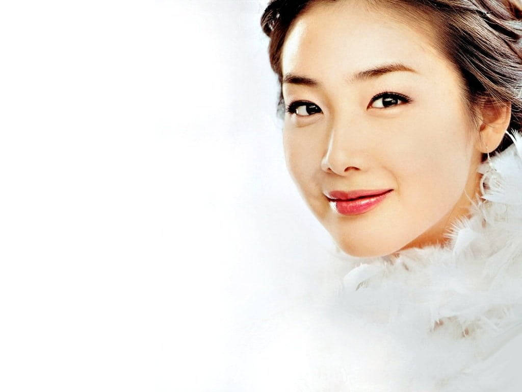 Woman Beautiful 桌布 壁紙 — 一個微笑的女人特寫肖像，她有深色眼睛和紅唇，穿著白色羽毛領，背景是明亮的白色。