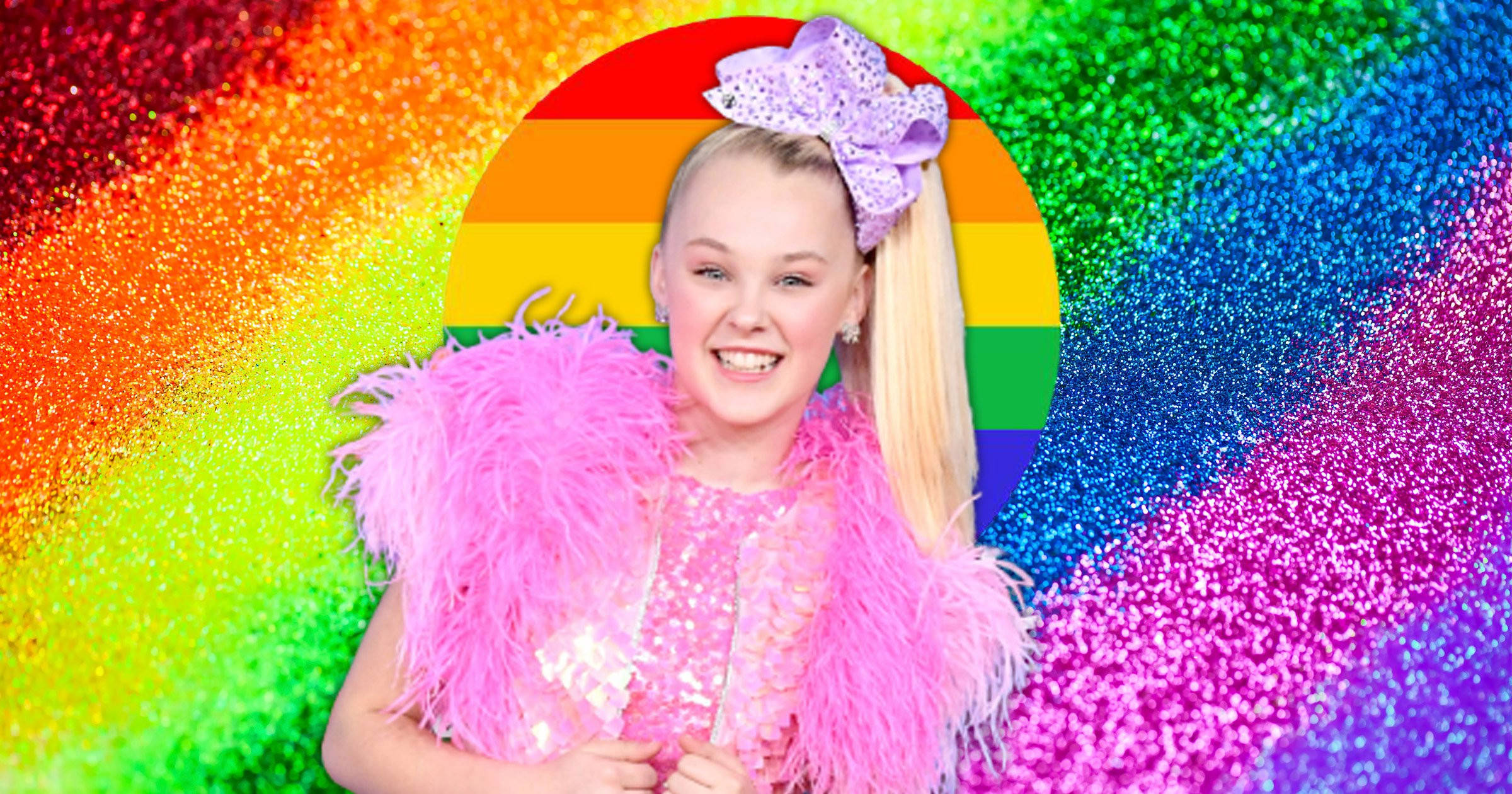 JoJo Siwa 桌布 壁紙 — 一個微笑的女孩，戴著巨大的紫色蝴蝶結，穿著粉紅色羽毛服裝，站在閃閃發光的彩虹背景前。