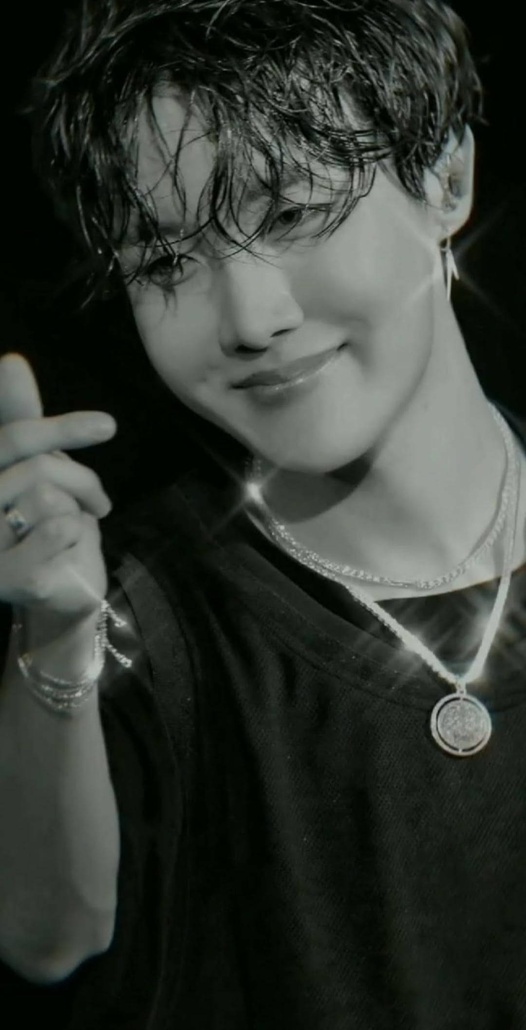 jhope 桌布 壁紙 — 一個微笑的年輕男子，濕髮，戴著多層項鍊和戒指的黑白特寫。